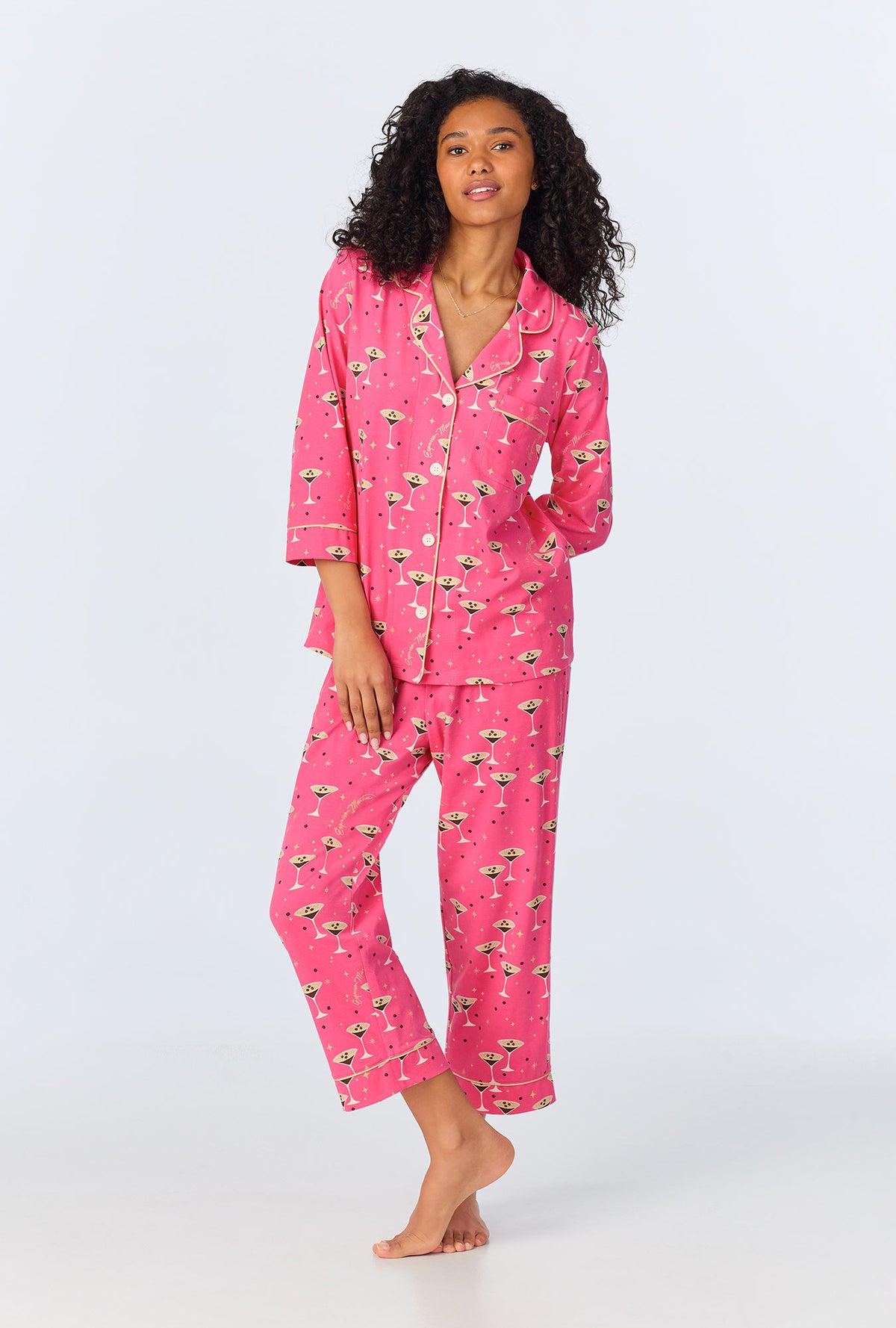 A lady wearing pink long sleeve pajama set with espresso martini print.