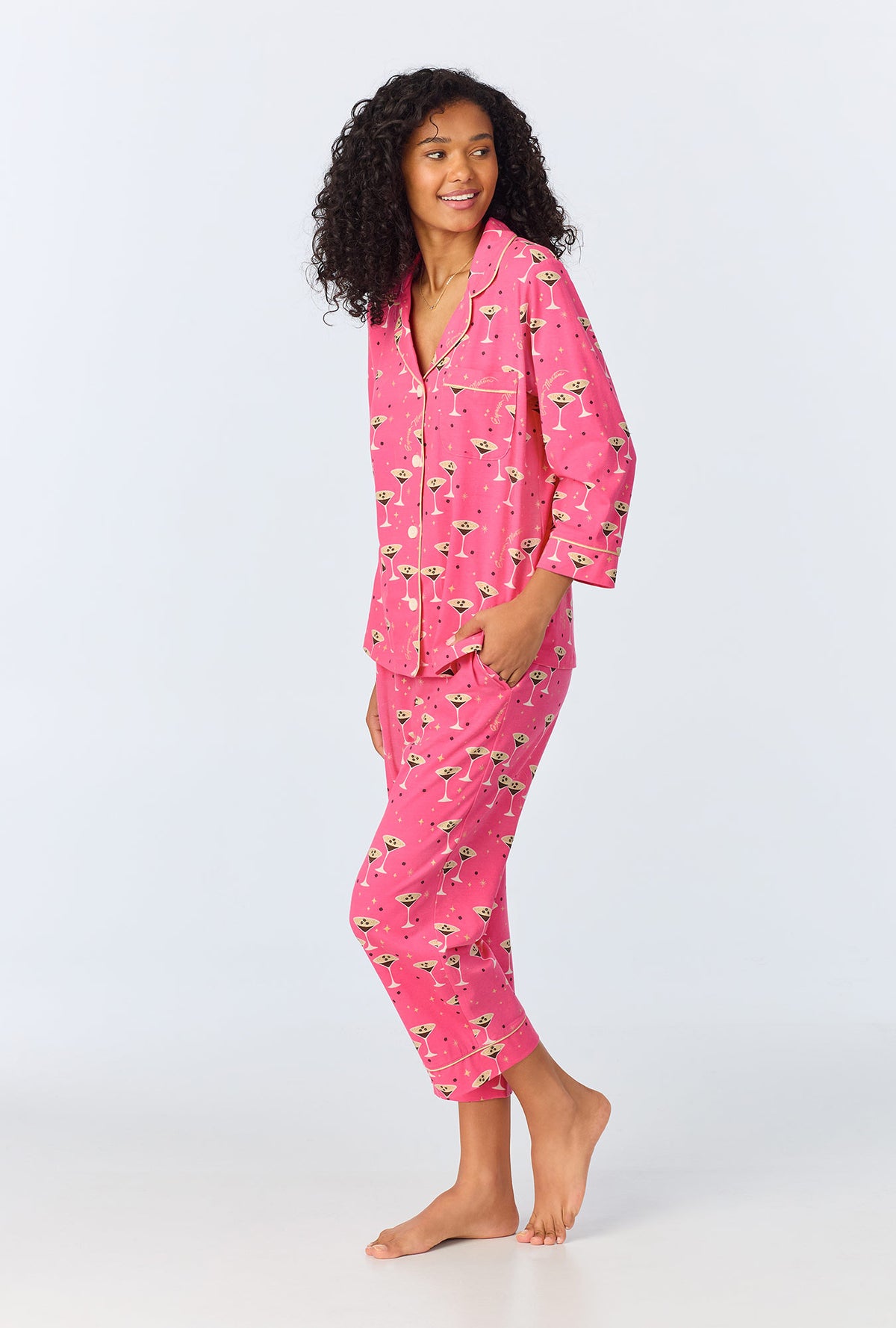 A lady wearing pink long sleeve pajama set with espresso martini print.