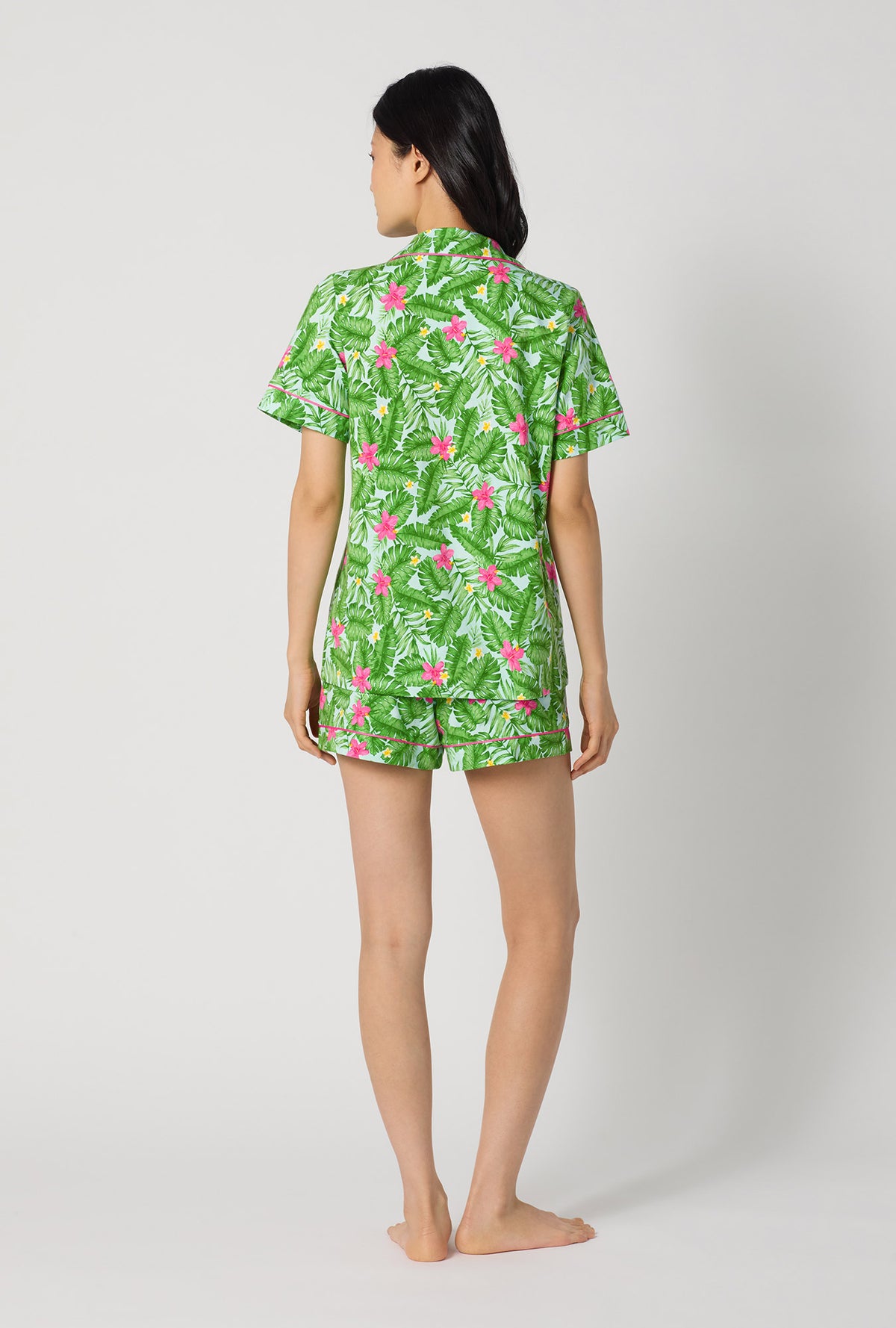 A Lady Wearing Monstera Bloom Short Sleeve Classic Shorty Stretch Jersey Pj Set facing back while looking to the side