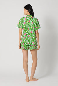 A Lady Wearing Monstera Bloom Short Sleeve Classic Shorty Stretch Jersey Pj Set facing back while looking to the side