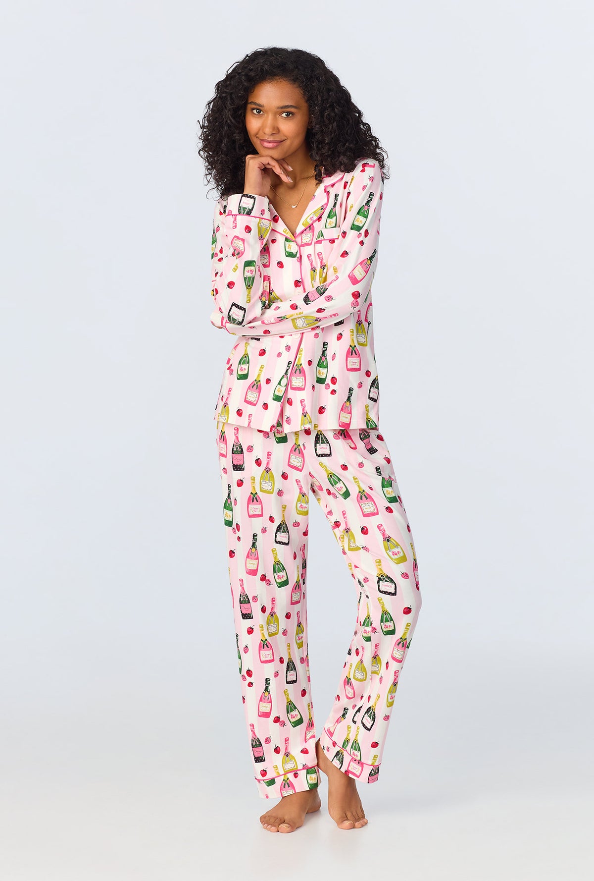 A lady wearing pink long sleeve pajama set with champagne toast print.