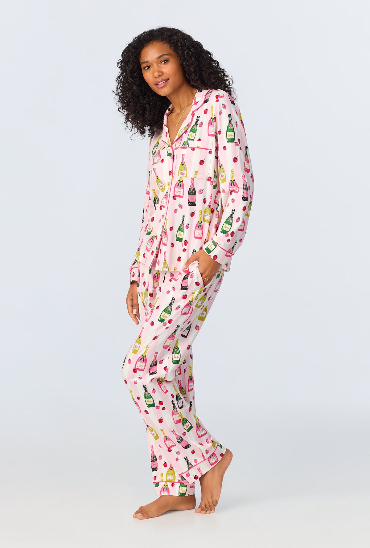 A lady wearing pink long sleeve pajama set with champagne toast print.