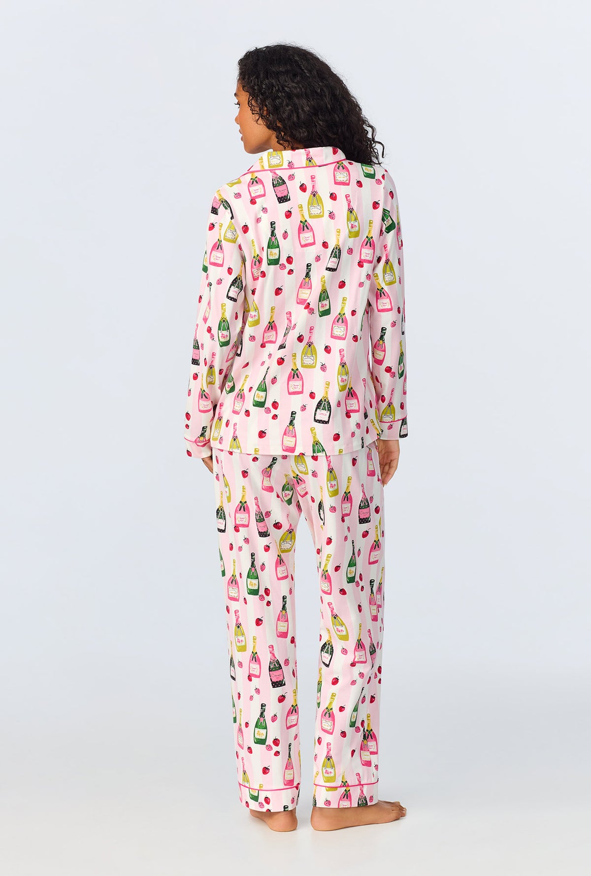 A lady wearing pink long sleeve pajama set with champagne toast print.