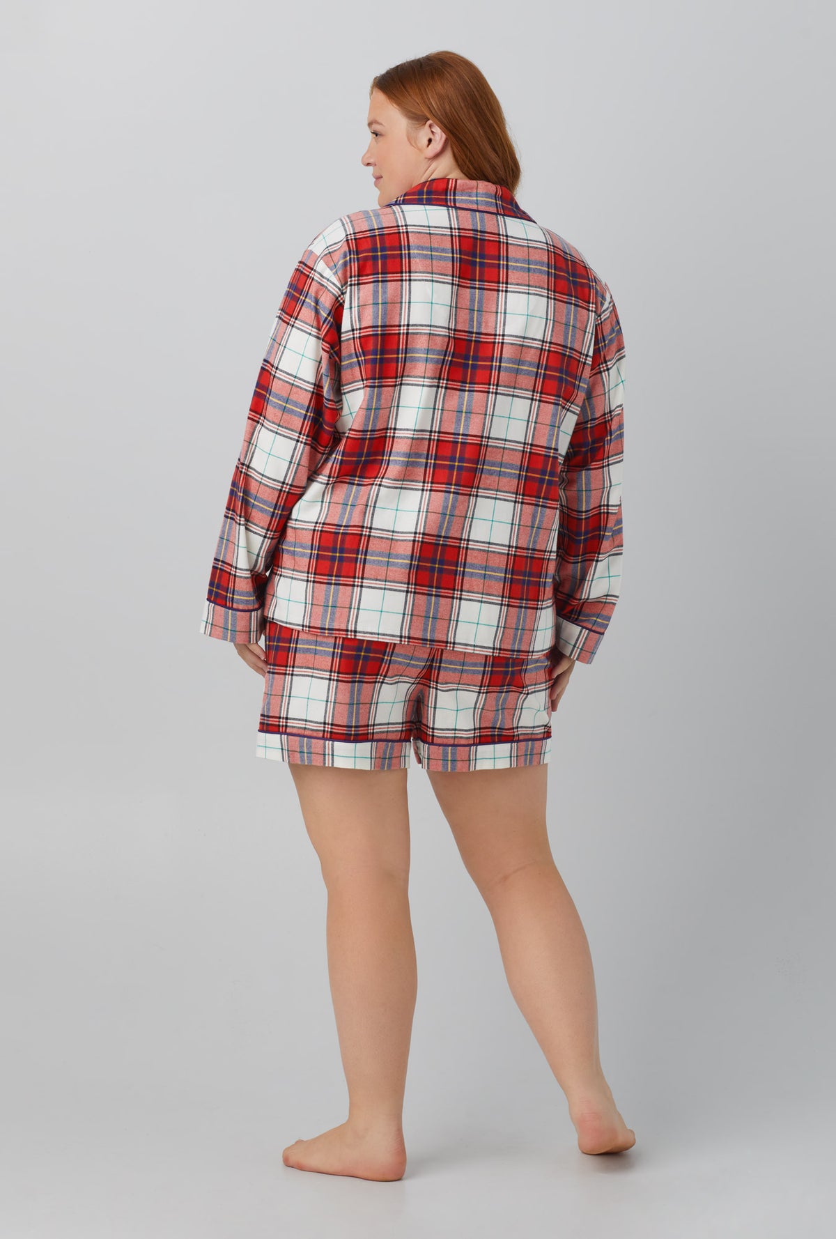 A lady wearing red Long Sleeve Classic Shorty Woven Cotton Portuguese Flannel plus PJ Set with Festive Tartan print