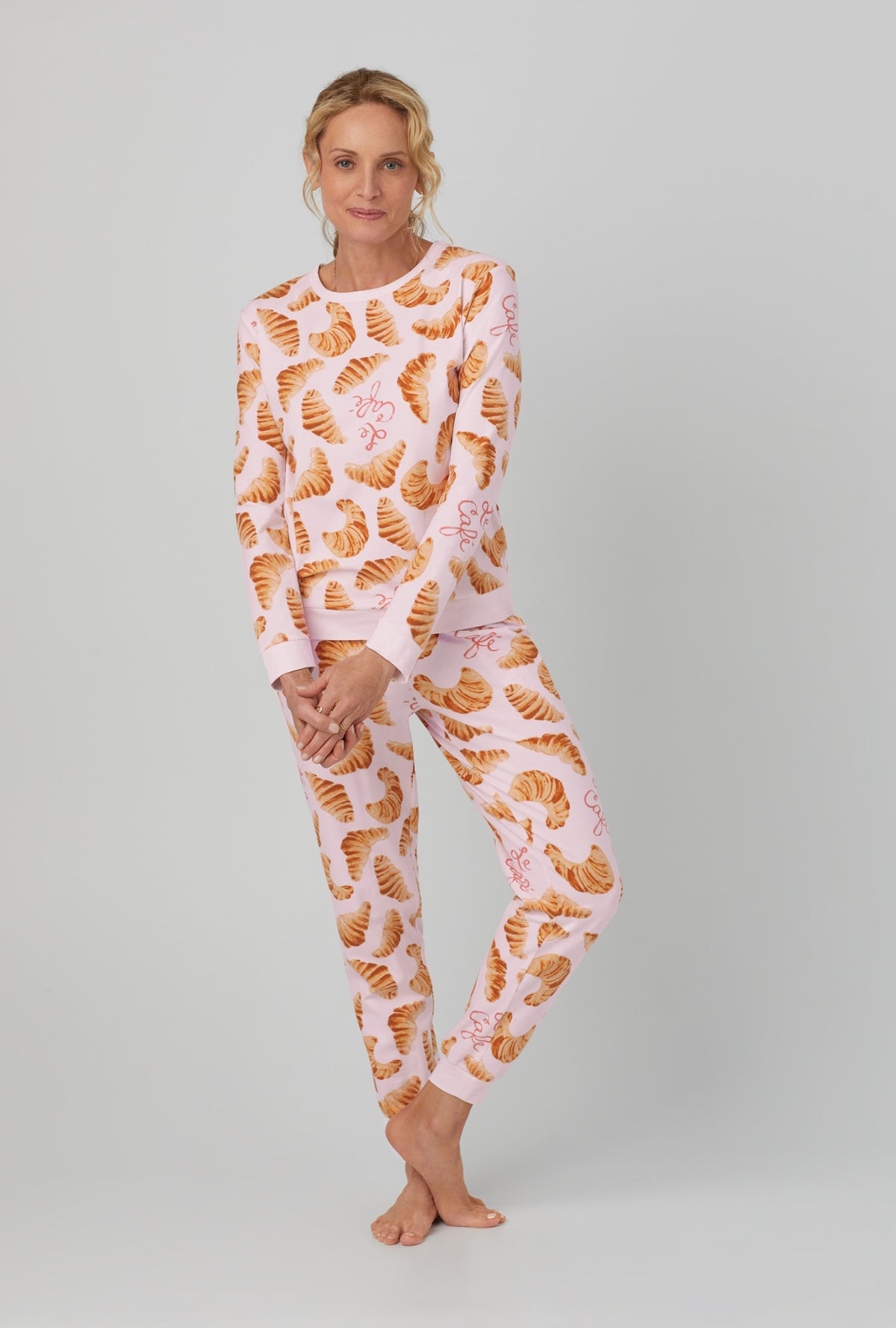 A lady wearing orange Long Sleeve Pullover Crew and Jogger Stretch Jersey PJ Set  with Le Cafe  print.