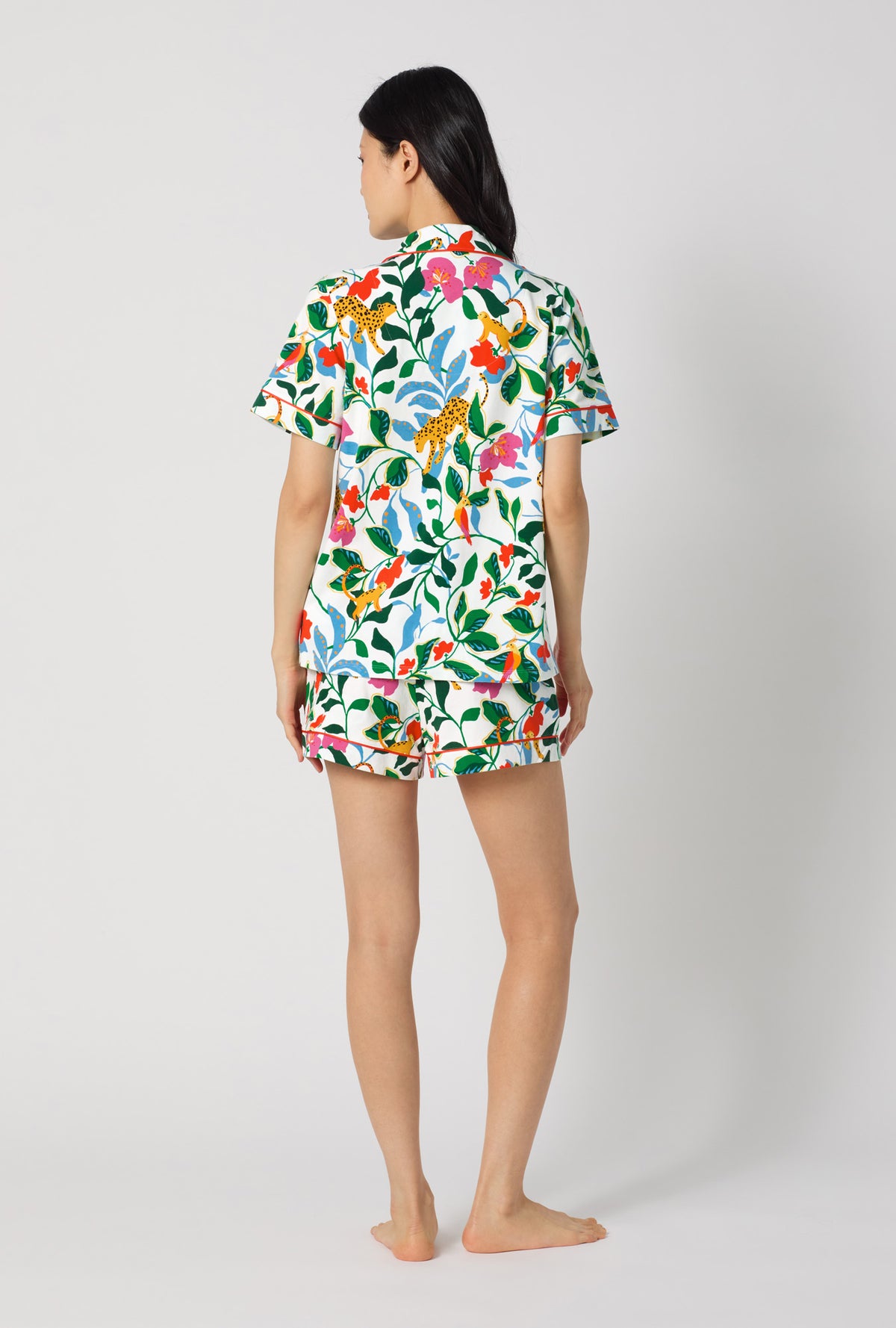 A Lady Wearing Jungle Serenade Short Sleeve Classic Shorty Stretch Jersey Pj Set facing back in a standing pose