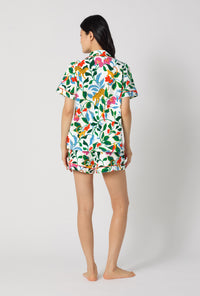 A Lady Wearing Jungle Serenade Short Sleeve Classic Shorty Stretch Jersey Pj Set facing back in a standing pose