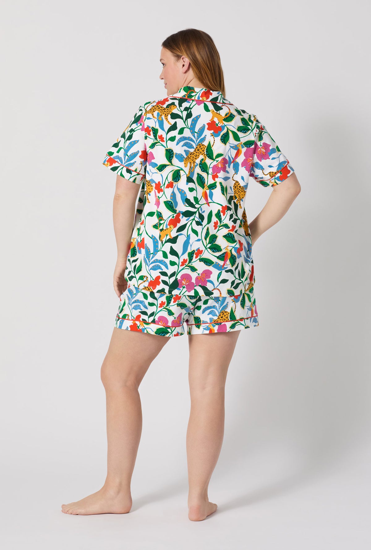 A Lady Wearing Plus Size Jungle Serenade Short Sleeve Classic Shorty Stretch Jersey Pj Set posing with a back view look