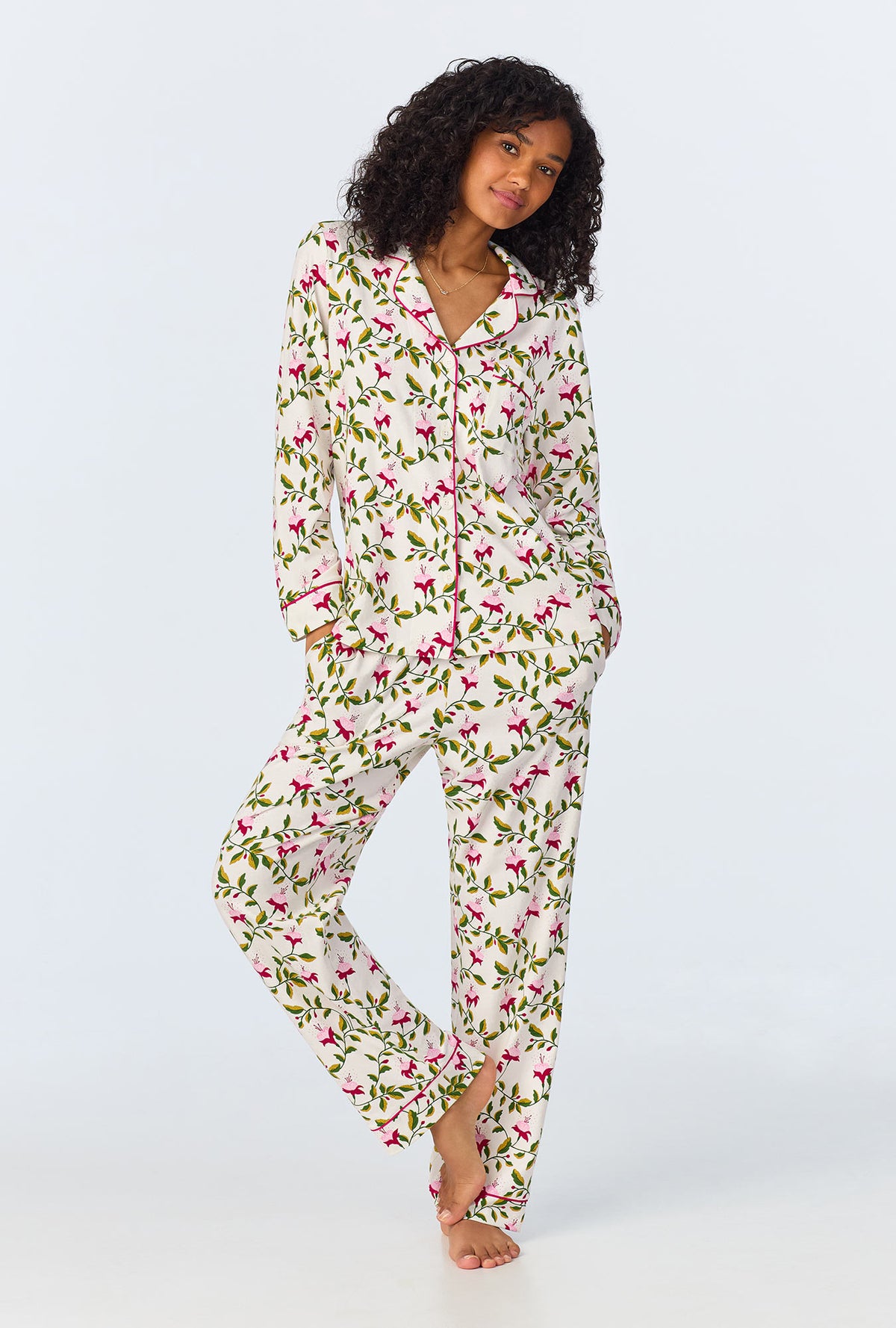 A lady wearing white long sleeve pajama set with dancing fuchsias print.