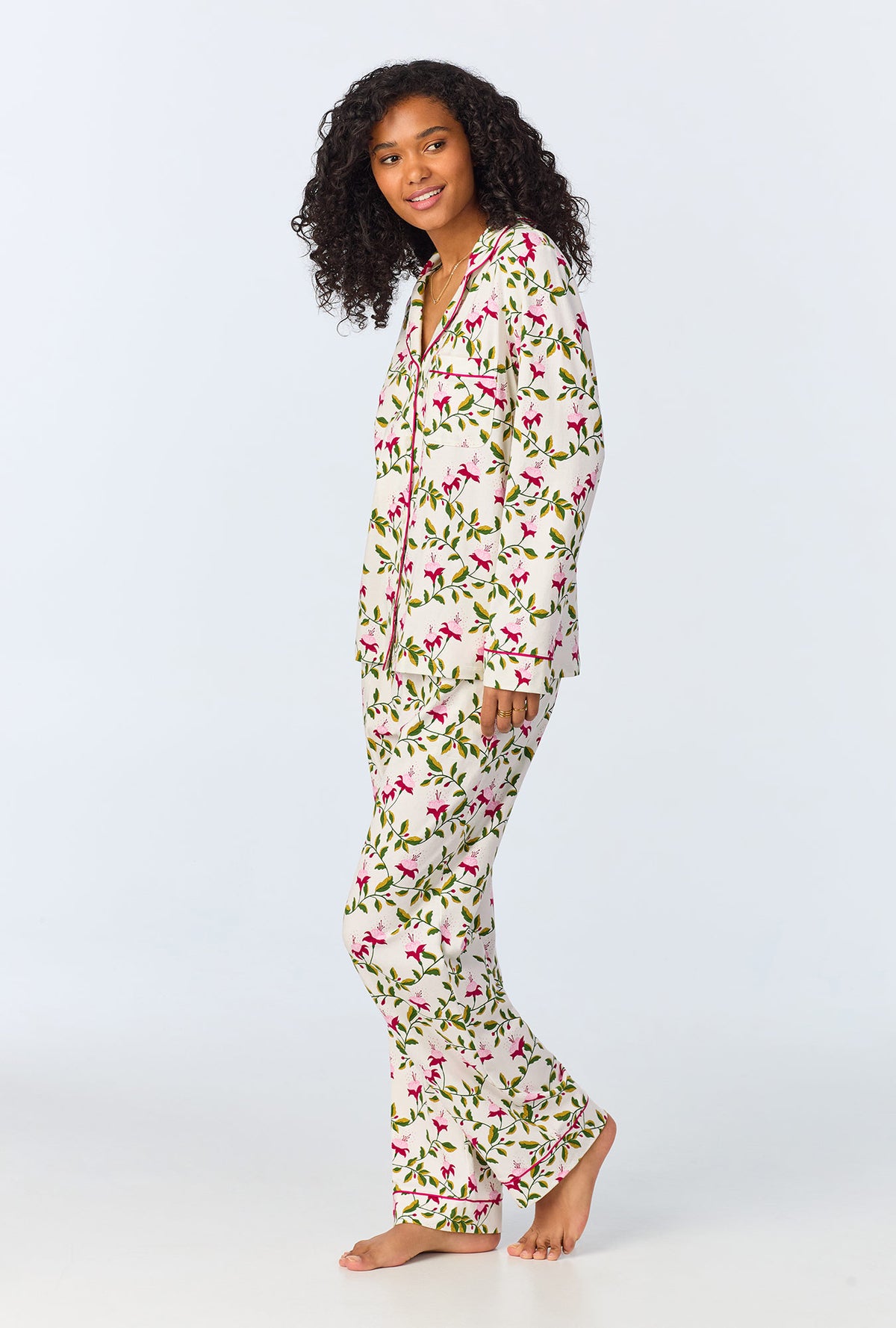 A lady wearing white long sleeve pajama set with dancing fuchsias print.