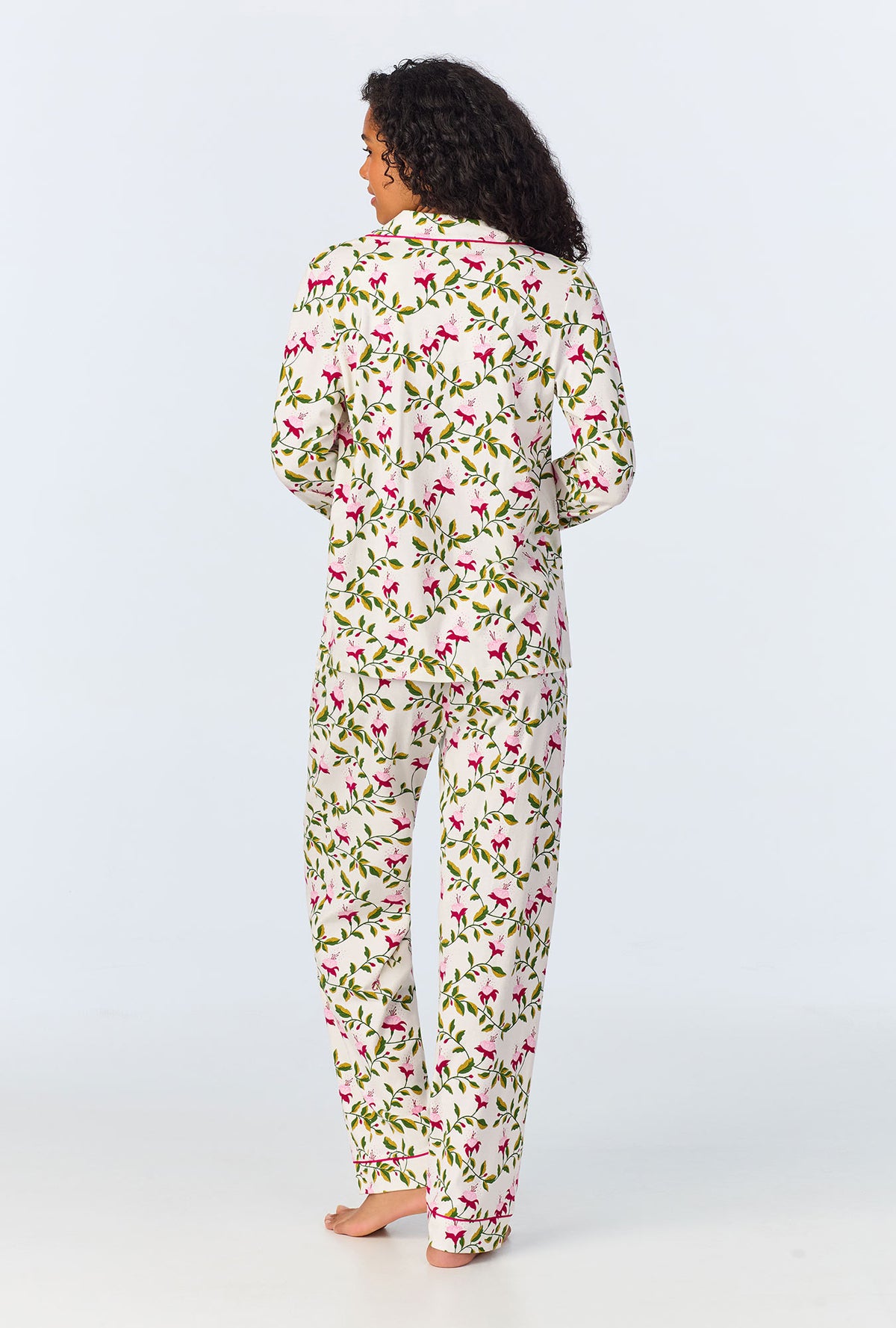 A lady wearing white long sleeve pajama set with dancing fuchsias print.