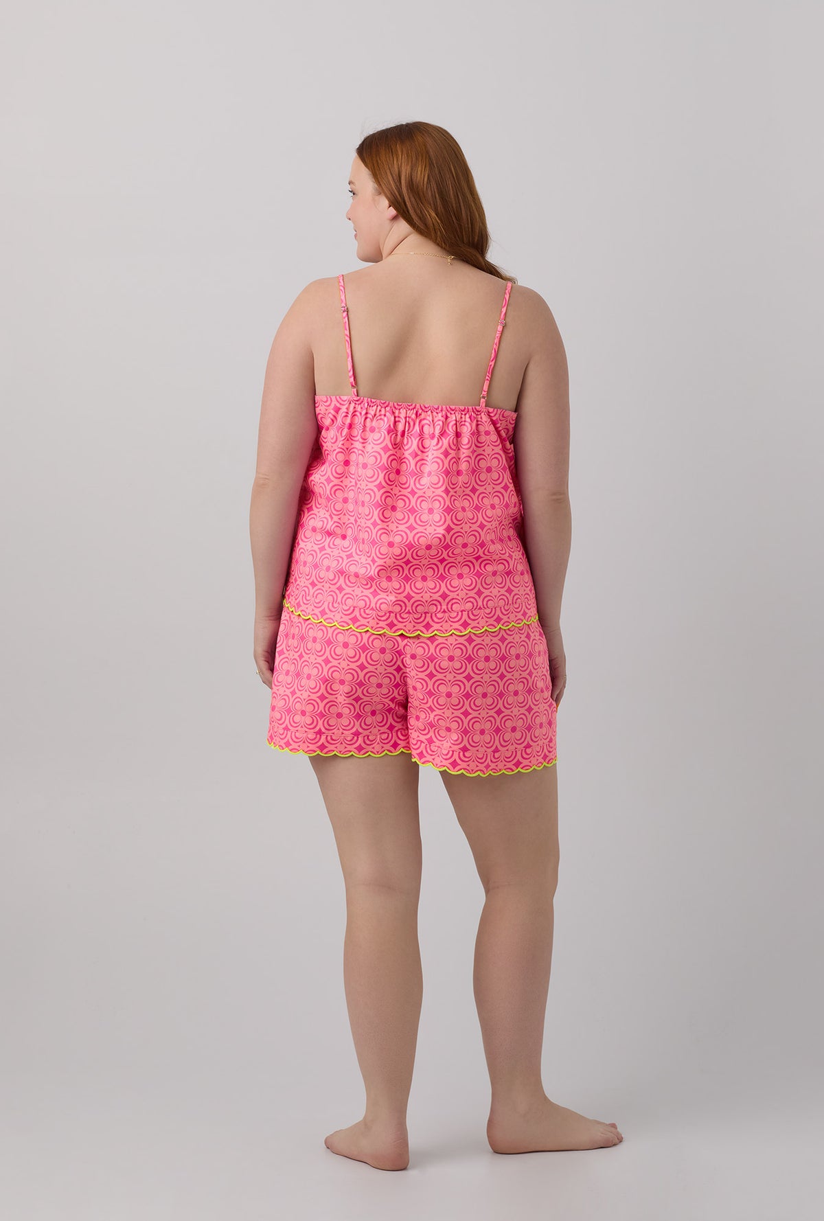 A lady wearing pink sleeveless women&#39;s scallop cami woven cotton poplin shorty plus size pj set with trina turk summer geo print.