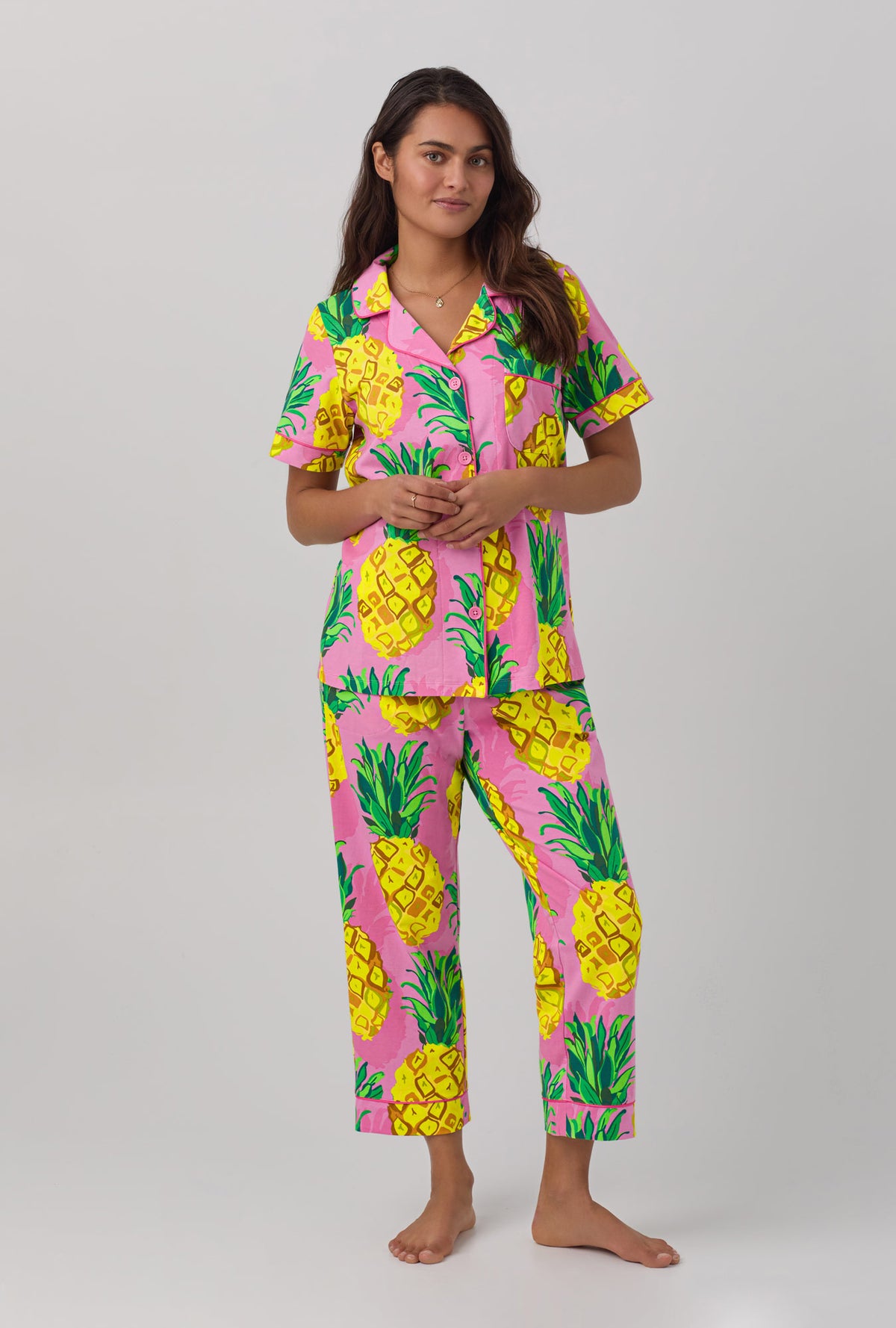 A lady wearing pink short sleeve classic stretch jersey cropped pj set with trina turk pineapples print.
