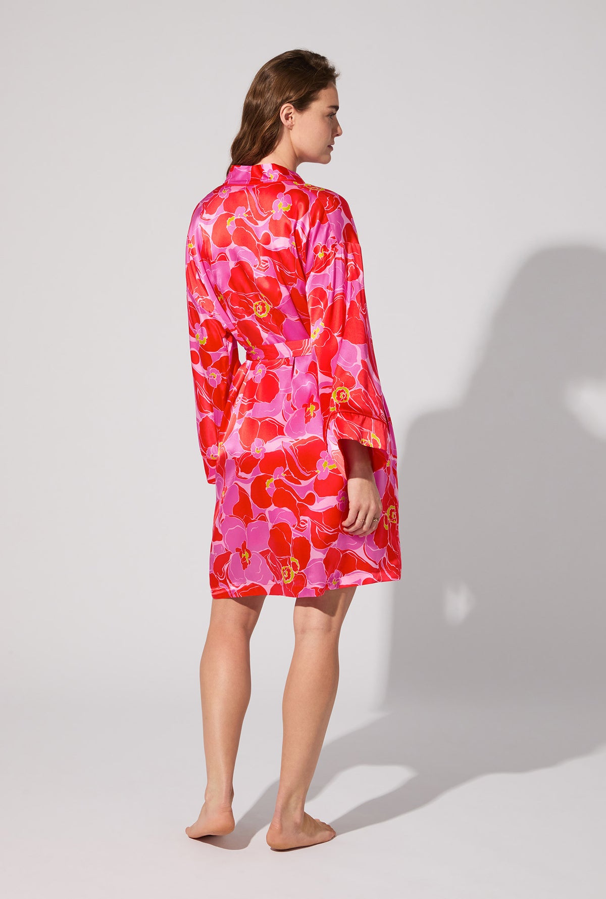 A lady wearing BedHead X Trina Turk Winter Orchids Banded Collar Washable Silk Robe