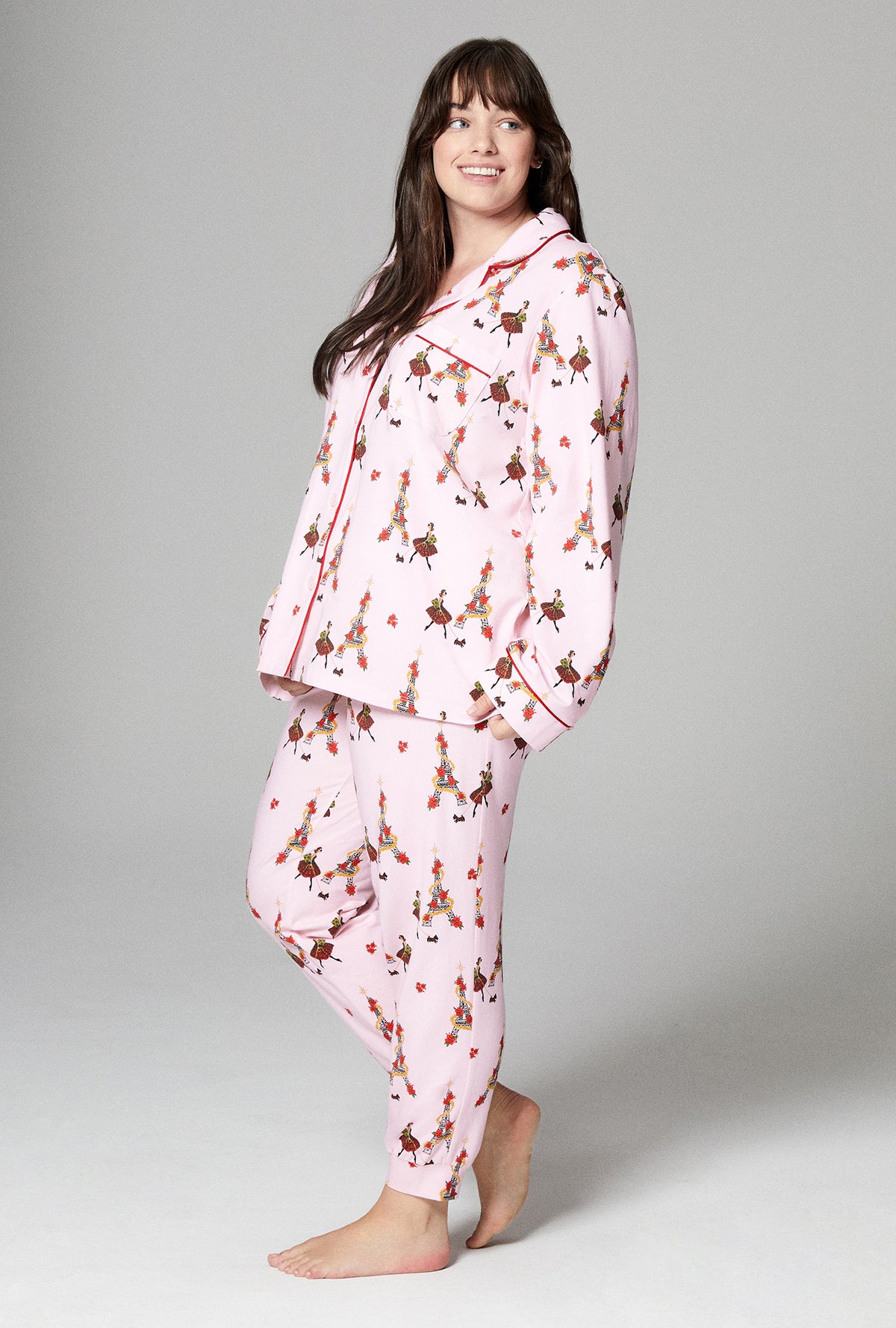 A lady wearing pink long sleeve and jogger embroidered stretch jersey plus pj set with christmas chic print.