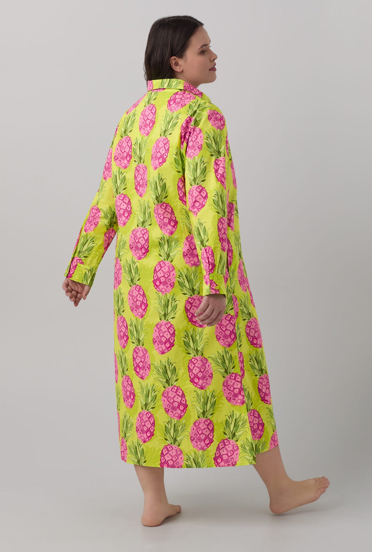 A lady wearing long sleeve maxi shirt with kiwi pineapple print
