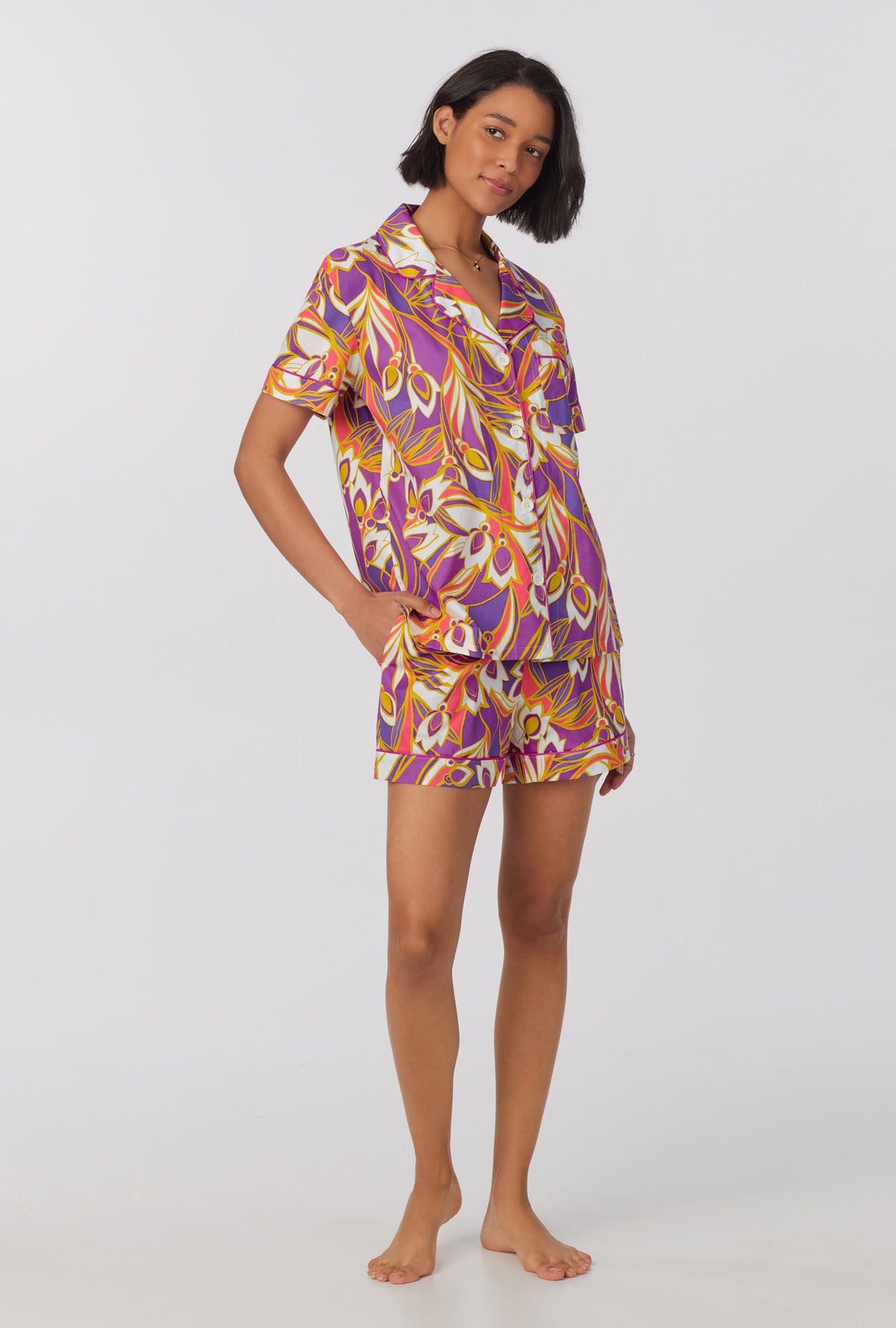 A lady wearing multi color short sleeve classic shorty woven cotton poplin pj set with sengal garden print.