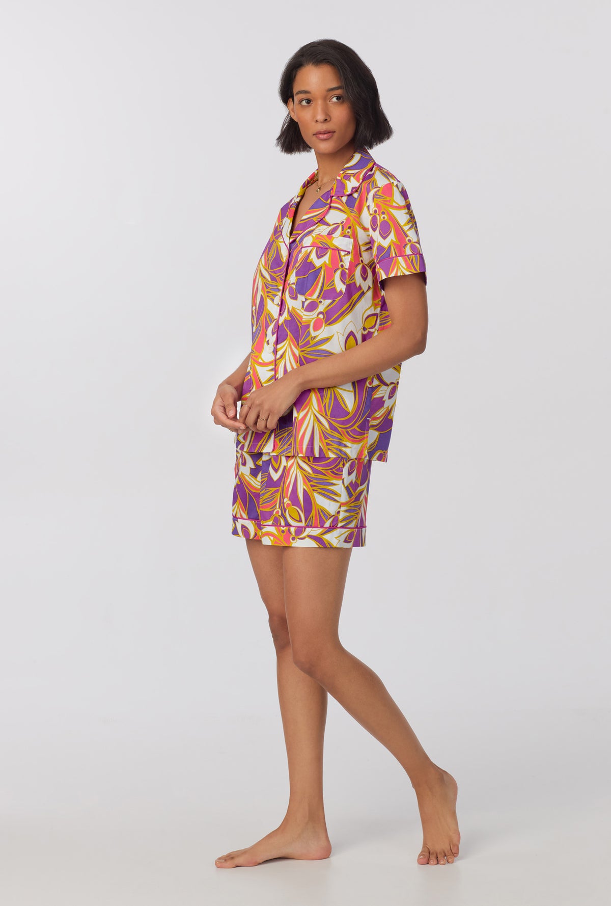 A lady wearing multi color short sleeve classic shorty woven cotton poplin pj set with sengal garden print.