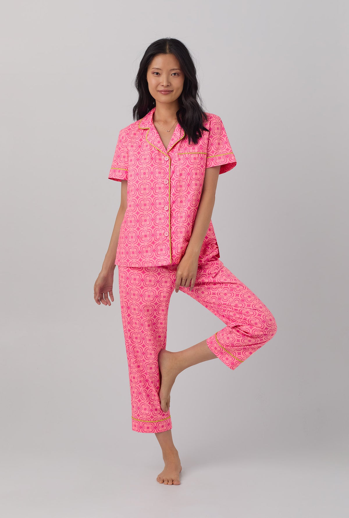 A lady wearing pink short sleeve cropped pj set with  summer geo print.