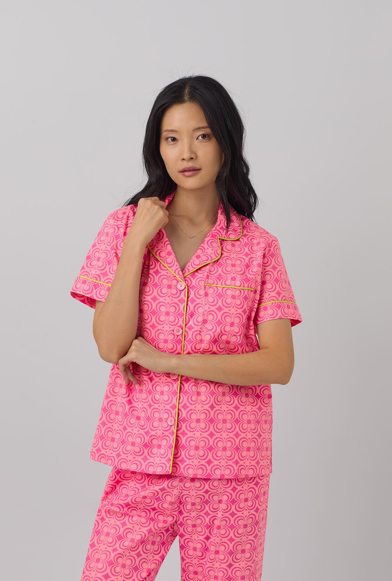 A lady wearing pink short sleeve cropped pj set with  summer geo print.