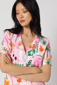 A Lady Wearing Tropical Daydream Short Sleeve Classic Stretch Jersey Cropped Pj Set facing front in a zoomed close up shot while looking down