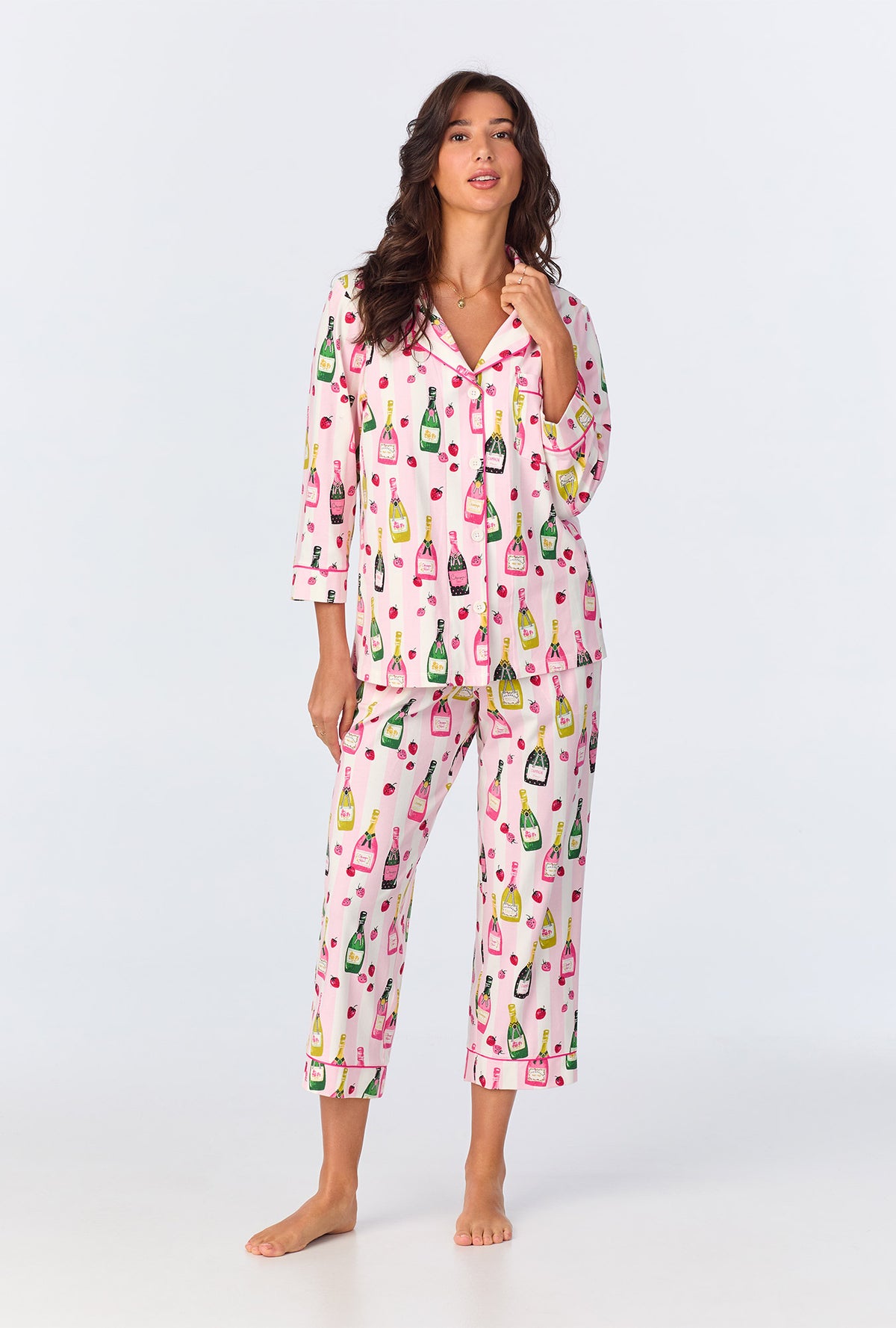 A lady wearing pink quarter sleeve pajama set with champagne toast print.