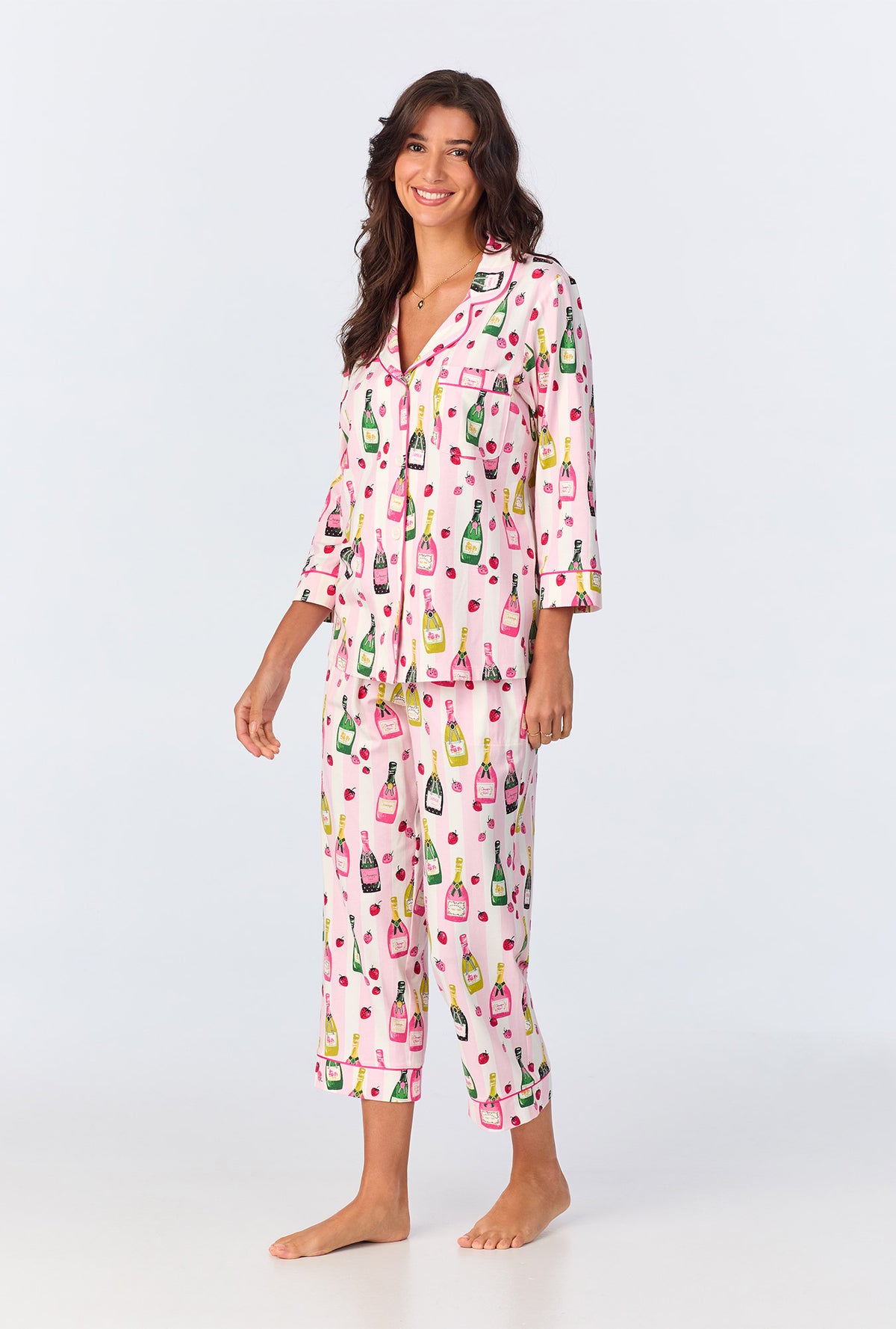 A lady wearing pink quarter sleeve pajama set with champagne toast print.