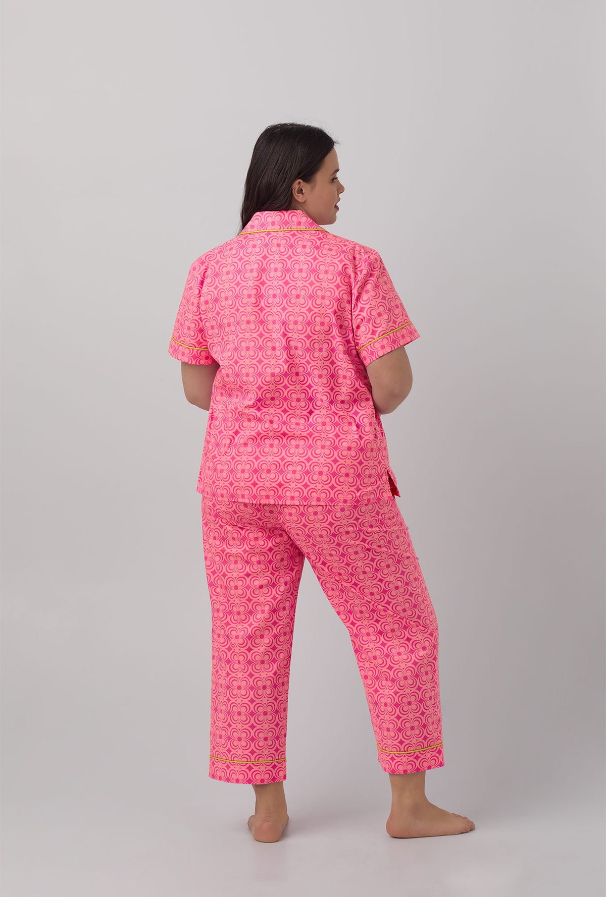 A lady wearing pink short sleeve cropped plus size pj set with summer geo print.