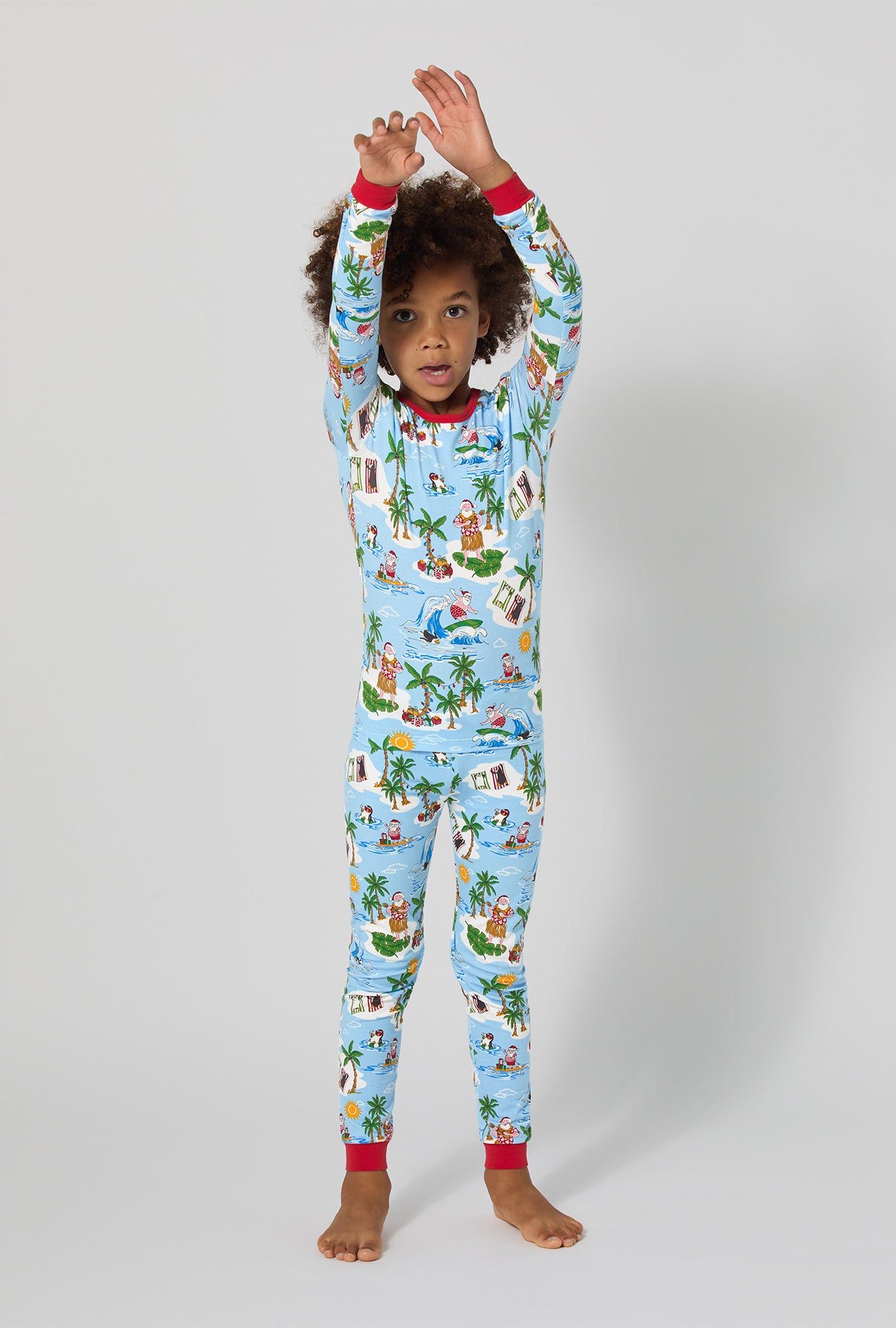 A girl wearing Surfin' Santa Long Sleeve Stretch Jersey Kids Pj Set