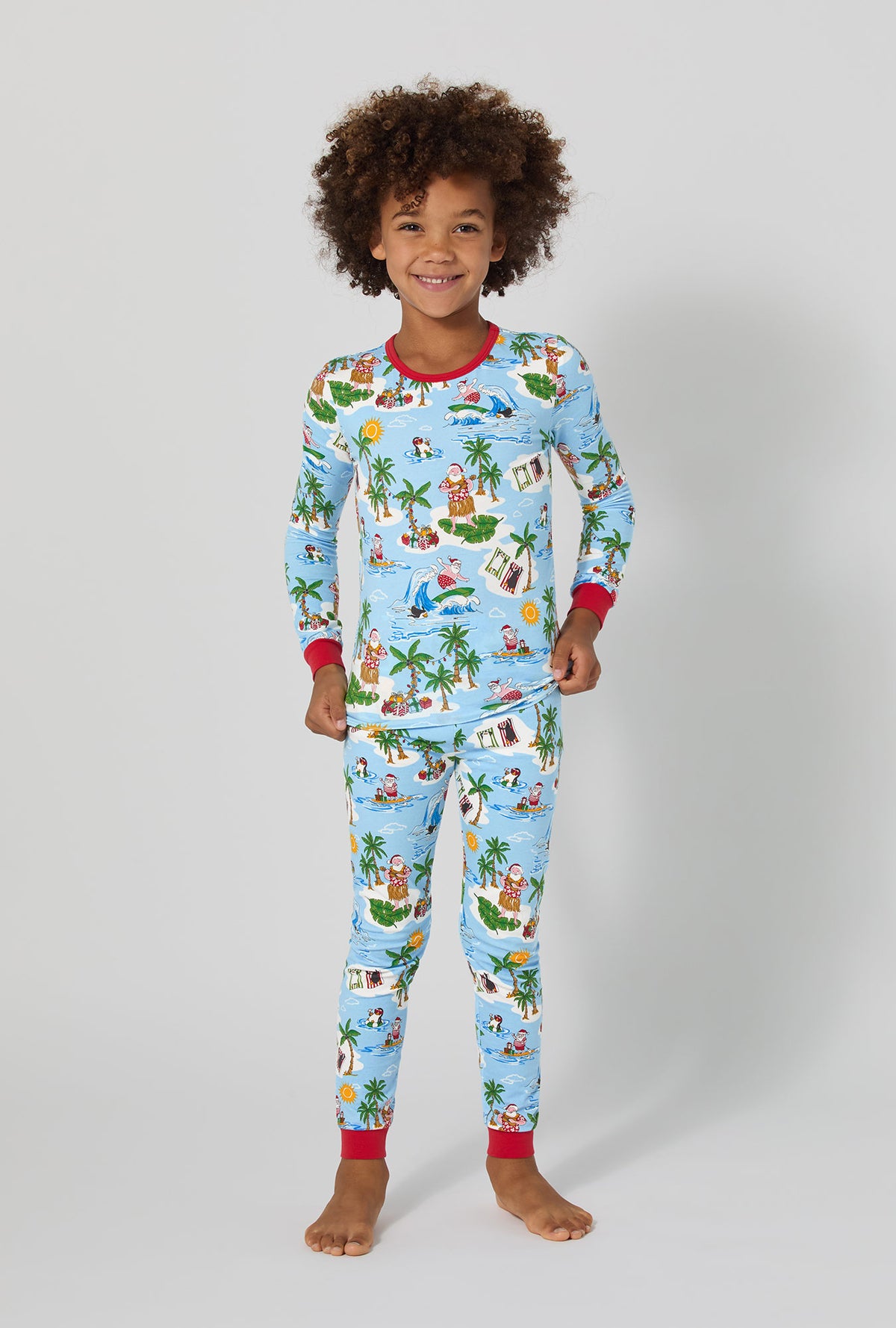 A girl wearing Surfin&#39; Santa Long Sleeve Stretch Jersey Kids Pj Set