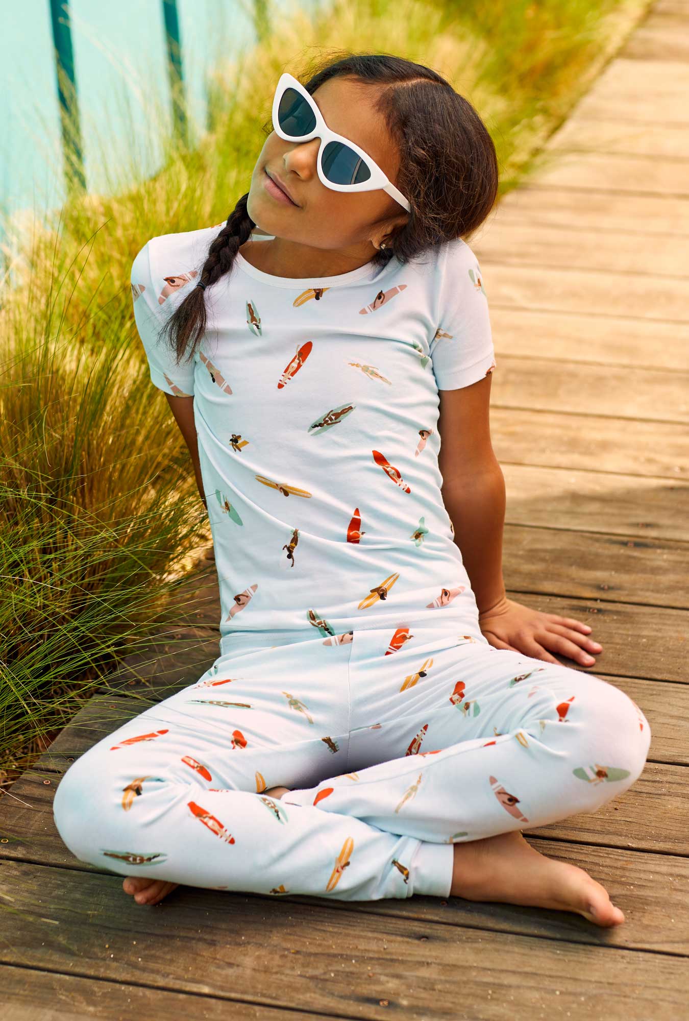 A girl wearing white short sleeve stretch jersey pj set with retro surf print.