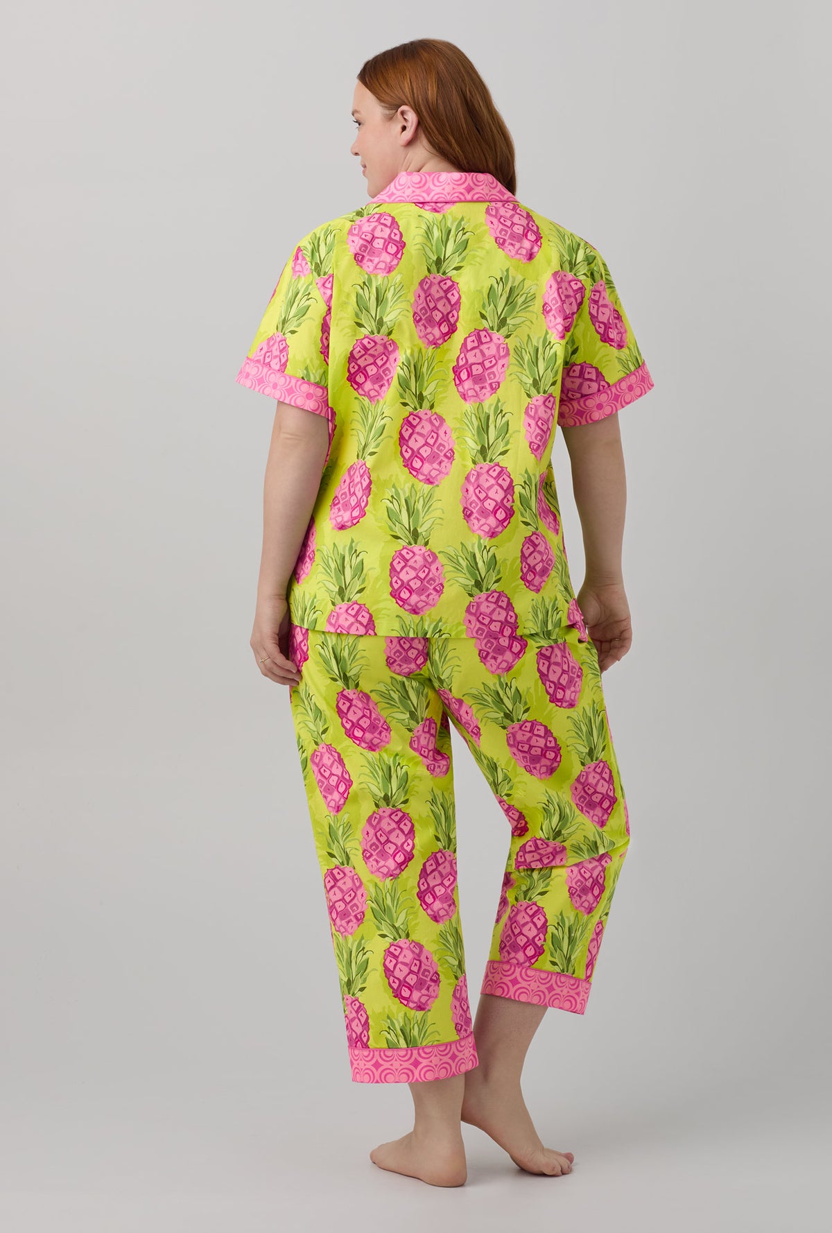 A lady wearing short sleeve classic cropped pj set with kiwi pineapple print