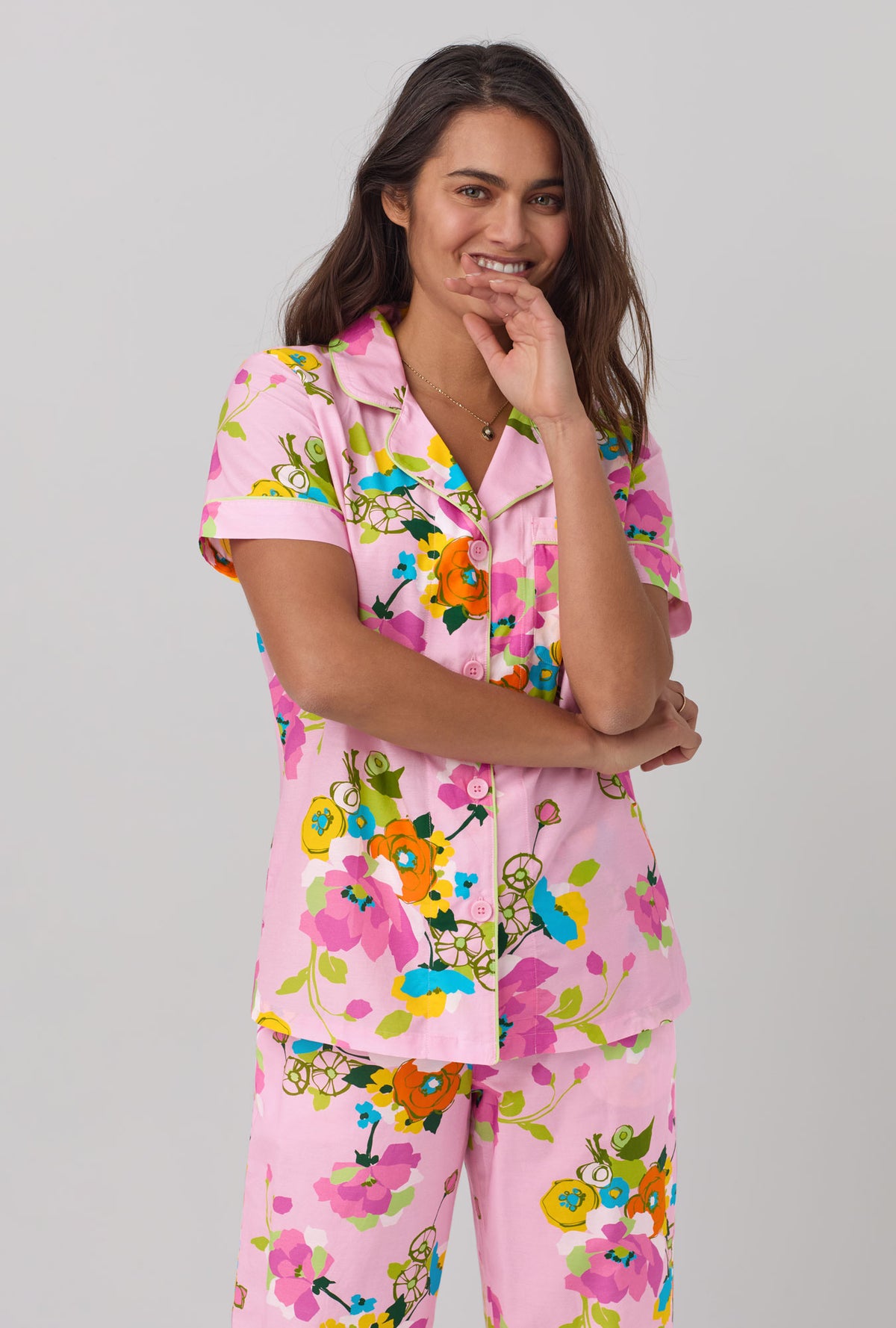 A lady wearing pink short sleeve classic woven cotton silk cropped pj set with trina turk summer blooms print.
