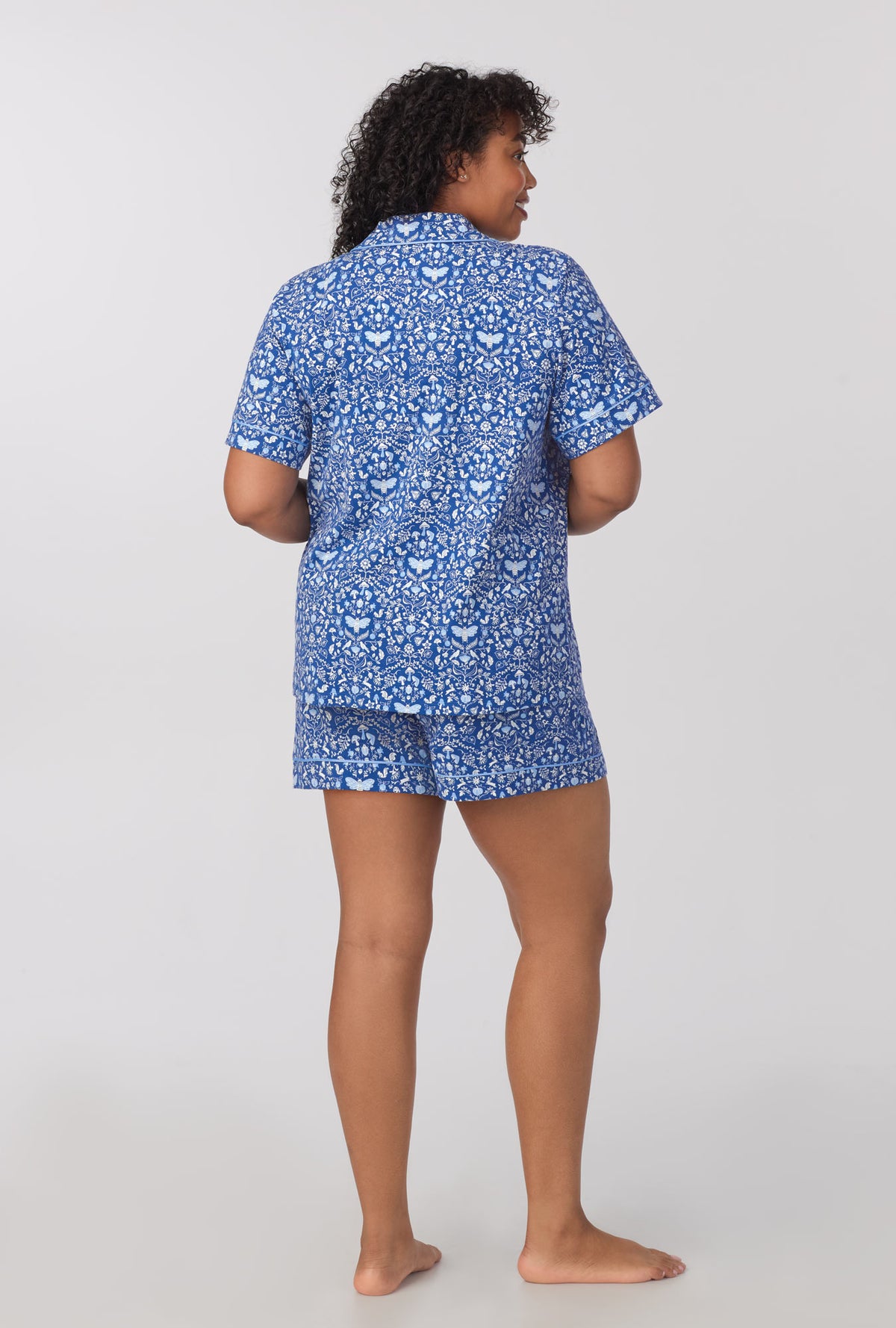 A lady wearing plus size Short Sleeve Classic Shorty Stretch Jersey PJ Set with Through The Woods print 