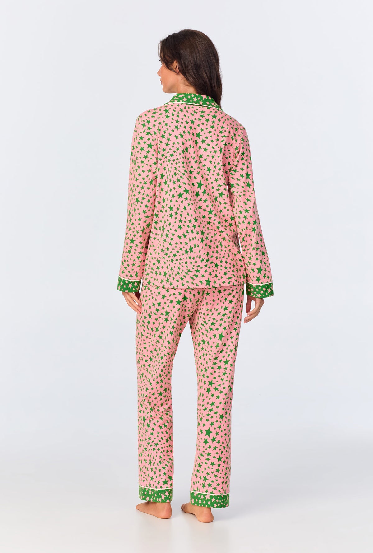 A lady wearing pink long sleeve pajama set with pink starlight print.