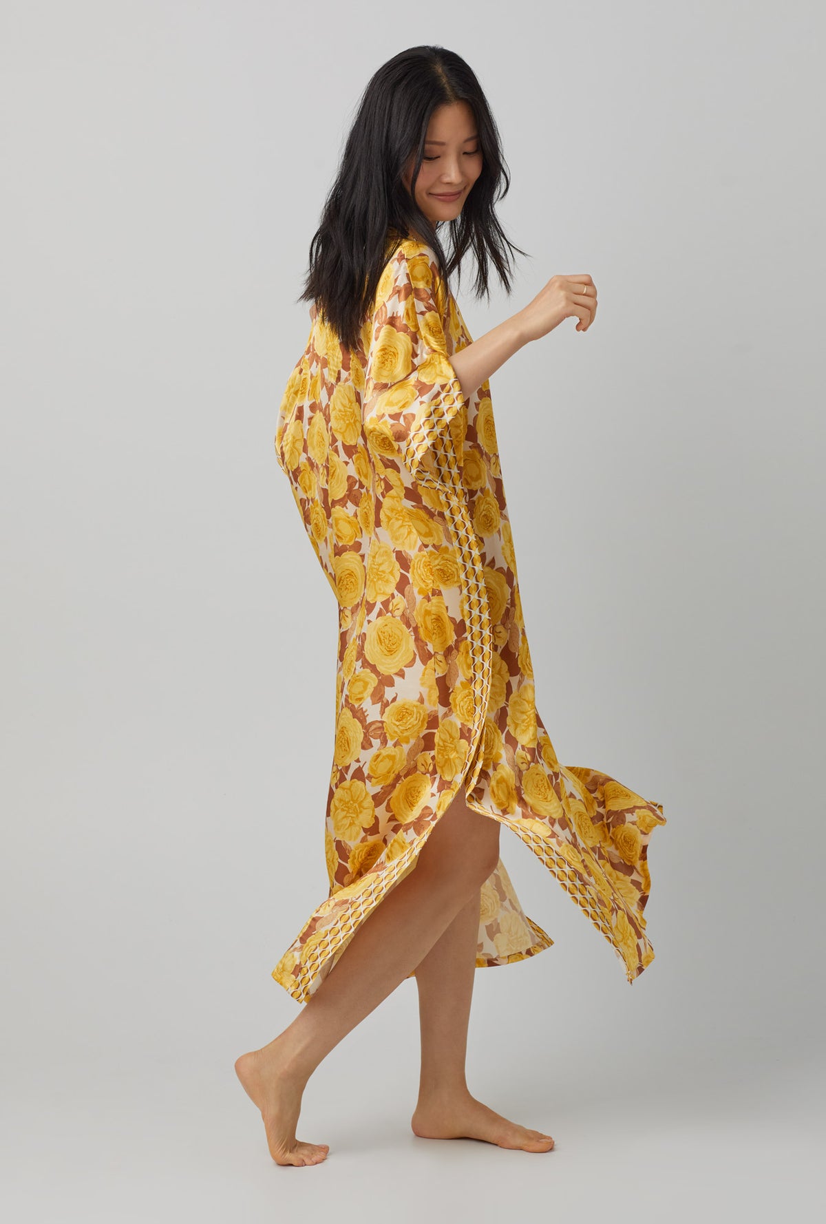 A lady wearing yellow Classic Washable Silk Caftan with Golden Roses print.