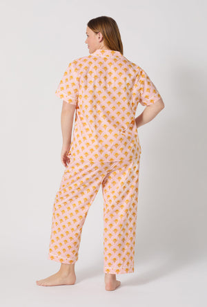 A Lady Wearing Plus Size Deco Sunset Short Sleeve Classic Woven Cotton Poplin Cropped Pj Set posing with a back view