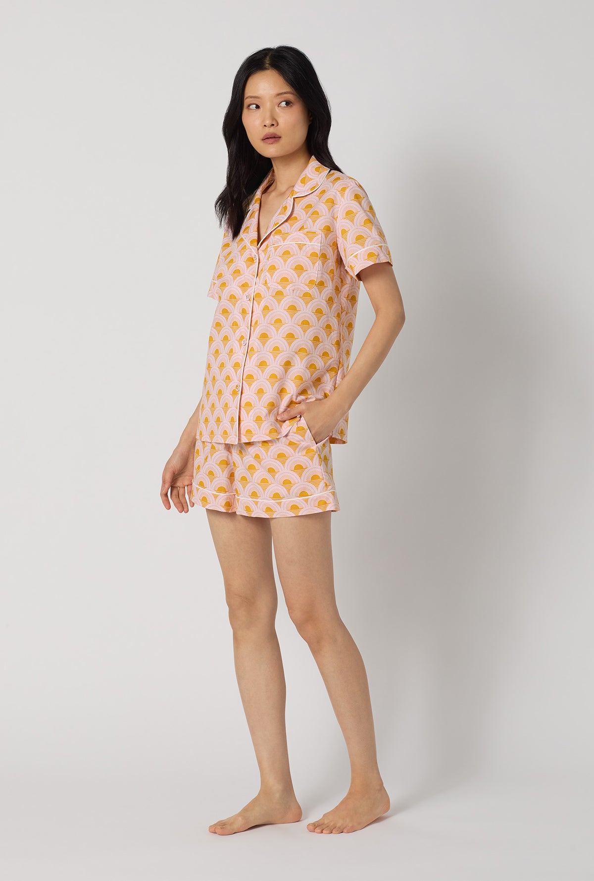 A Lady Wearing Deco Sunset Short Sleeve Classic Woven Cotton Poplin Shorty Pj Set facing front while looking to the side