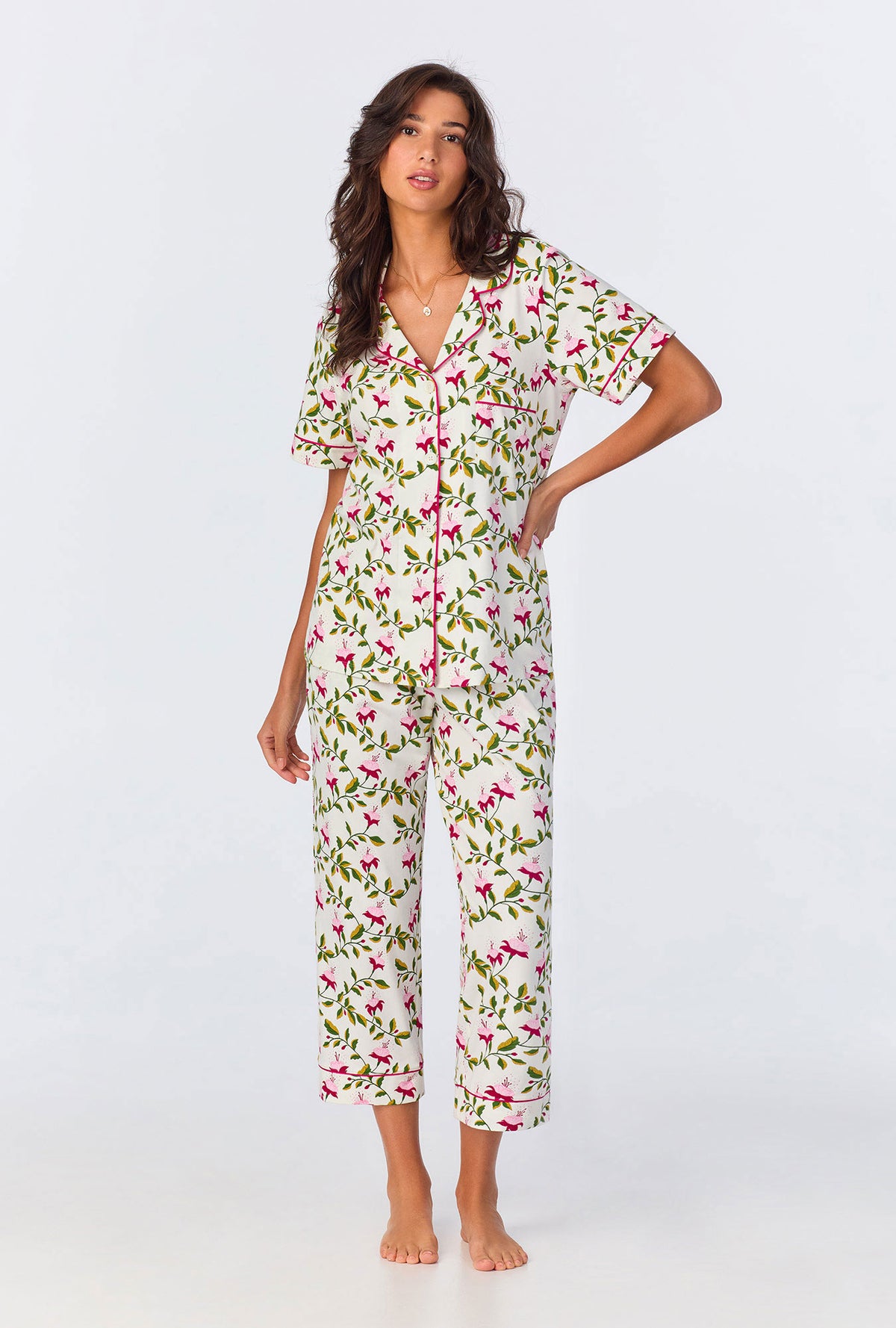 A lady wearing white short sleeve pajama set with dancing fuchsias print.