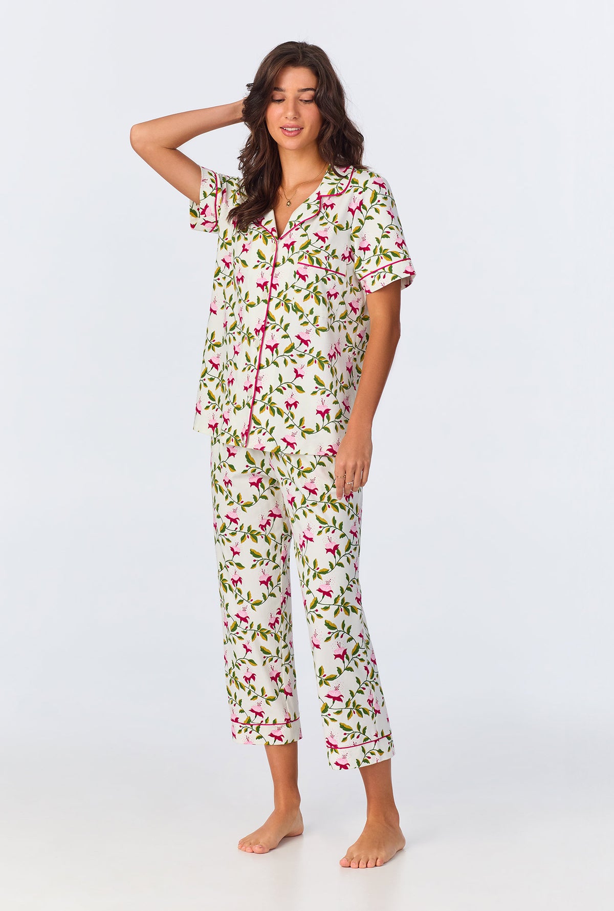 A lady wearing white short sleeve pajama set with dancing fuchsias print.