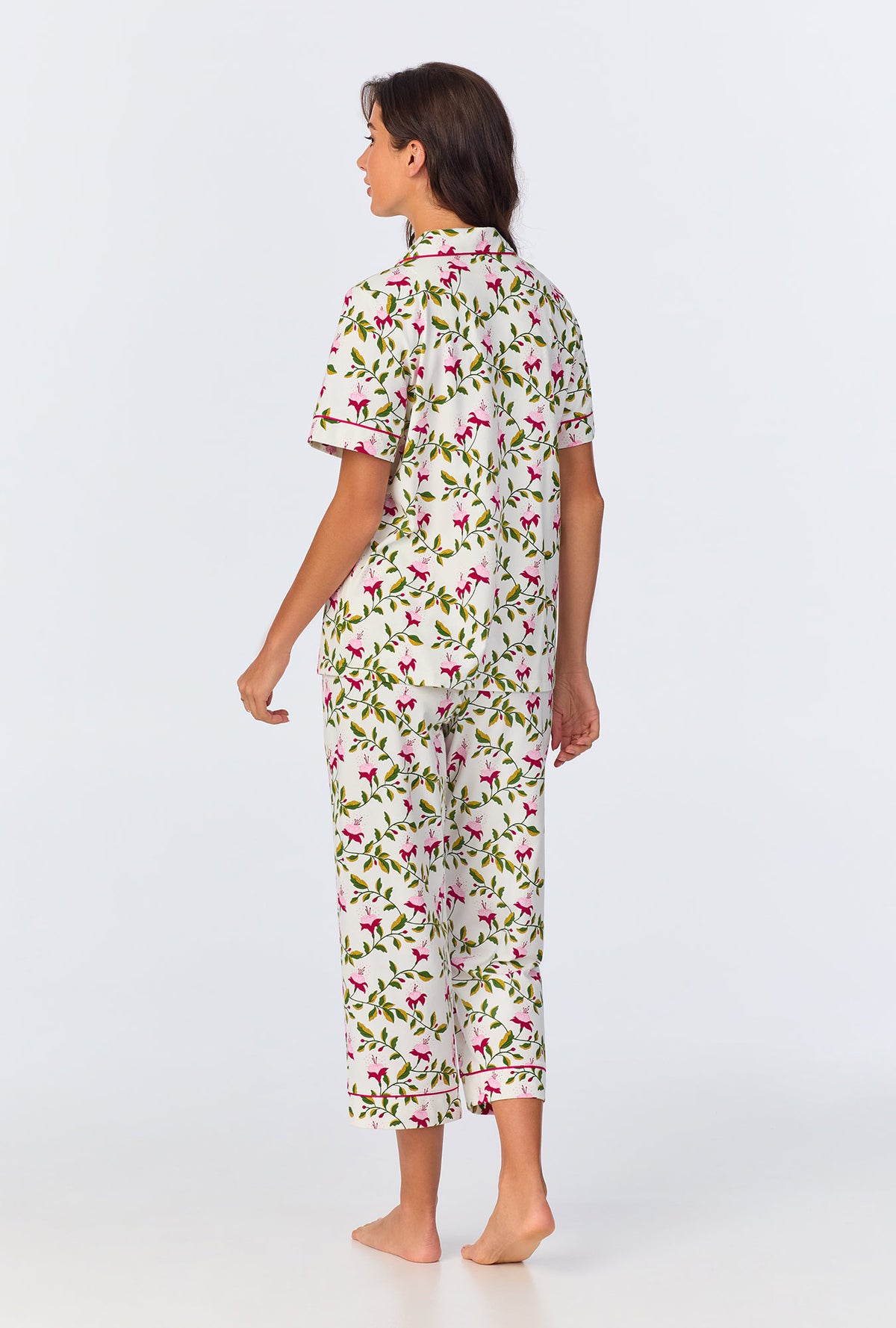 A lady wearing white short sleeve pajama set with dancing fuchsias print.