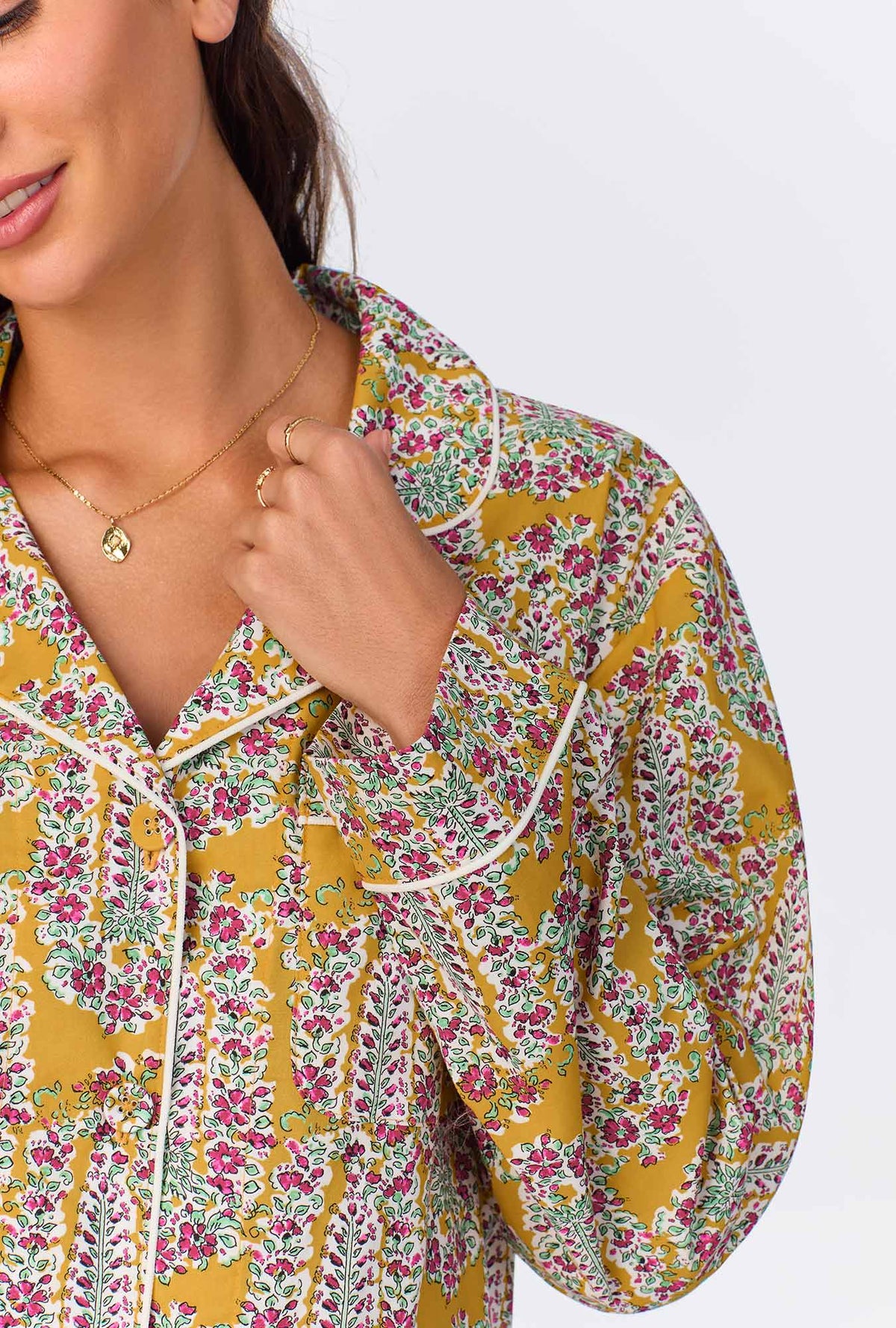 A lady wearing yellow long sleeve pajama set with budding blooms print.