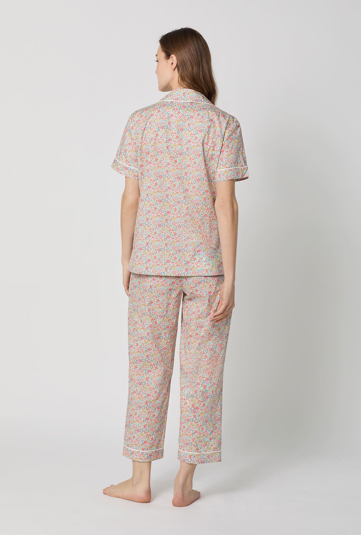 A lady wearing Emma & Georgina Short Sleeve Classic Woven Tana Lawn® Cropped Pj Set Made With Liberty Fabric back view