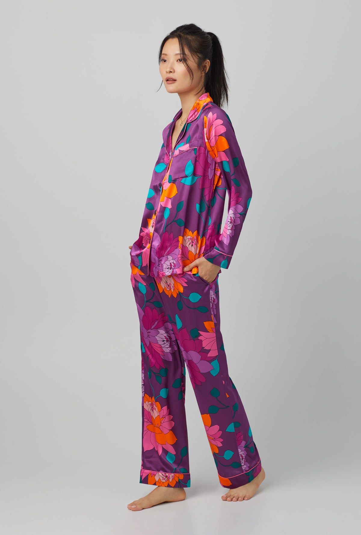 A lady wearing purple long sleeve classic washable silk pj set with trina turk evening blooms print.