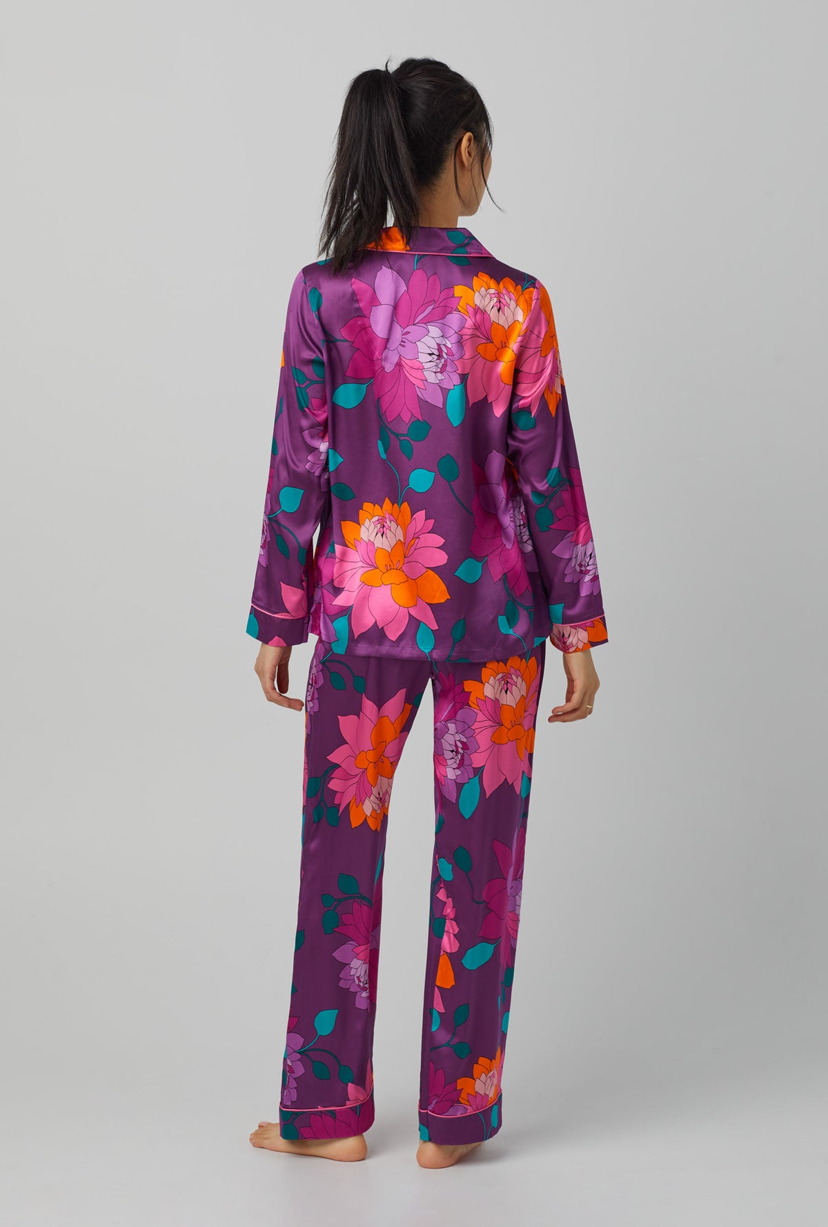 A lady wearing purple long sleeve classic washable silk pj set with trina turk evening blooms print.