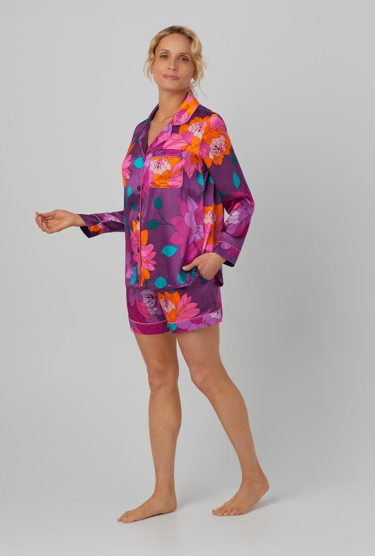 A lady wearing purple long sleeve classic shorty washable silk pj set with trina turk evening blooms print.