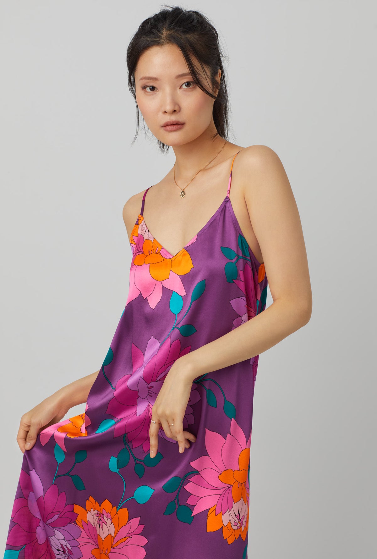A lady wearing purple long sleeve maxi washable silk chemise with trina turk evening blooms print.