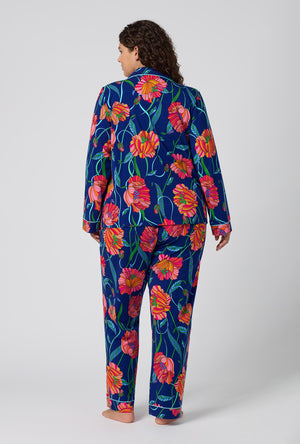 A Lady Wearing Plus Size BedHead x Trina Turk Linear Poppy Long Sleeve Classic Stretch Jersey Pj Set in a back view pose