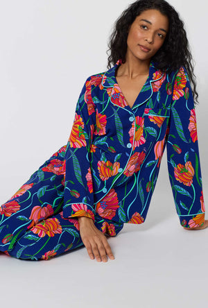 A Lady Wearing BedHead x Trina Turk Linear Poppy Long Sleeve Classic Stretch Jersey Pj Set in a sitting close up pose