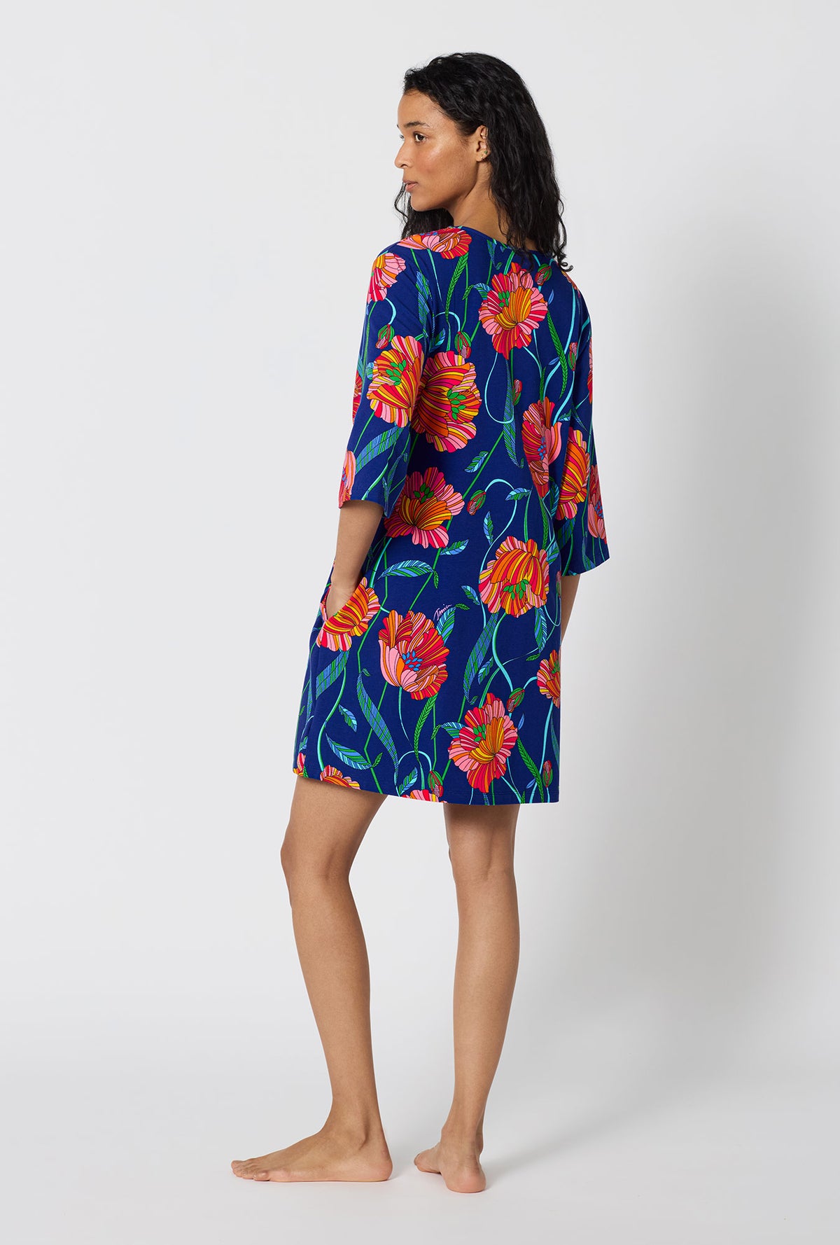 A Lady Wearing BedHead x Trina Turk Linear Poppy Stretch Jersey Sleep Dress in a side turned back view pose